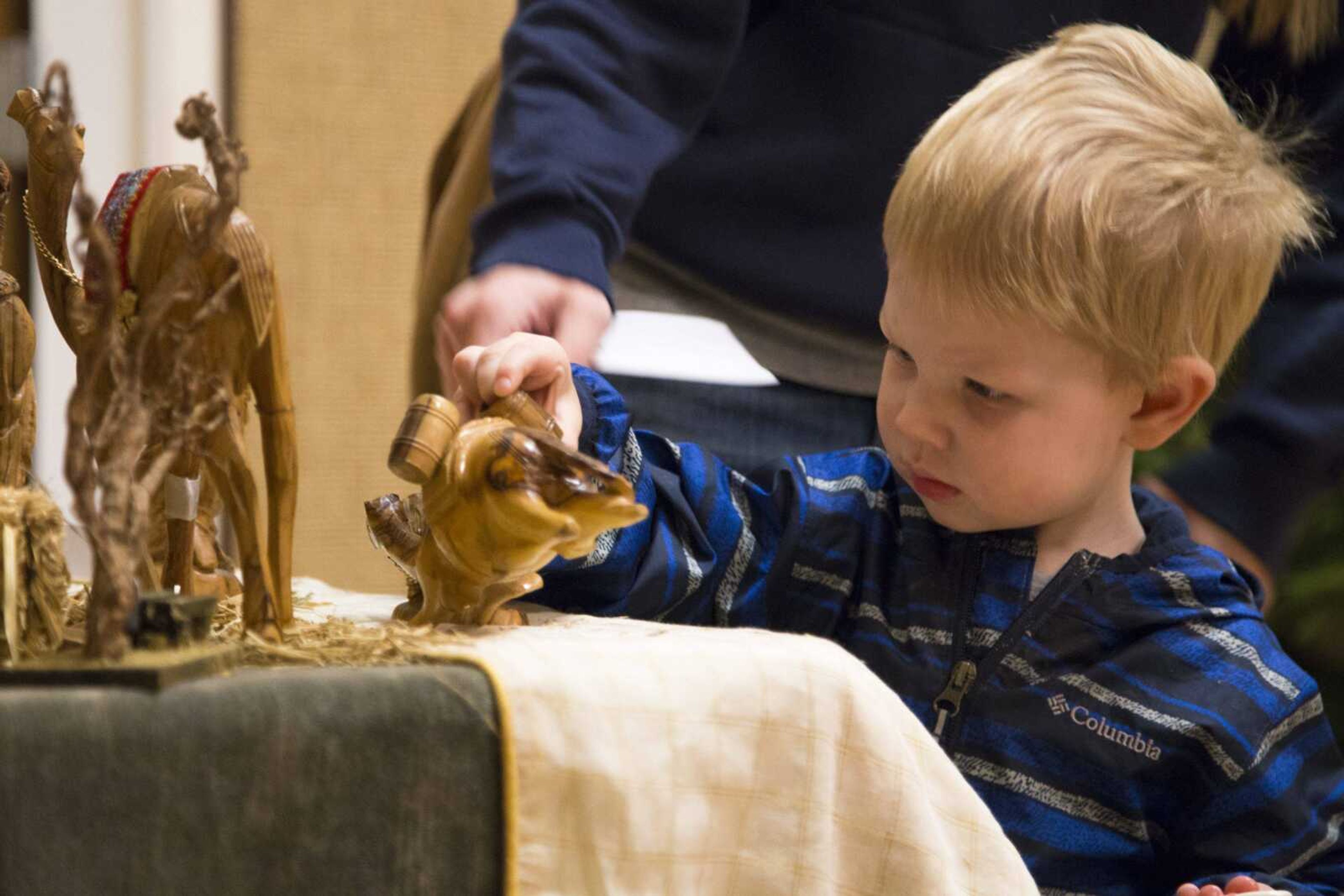 Mason Dean, 2, picks up a camel figurine while viewing a olive wood nativity scene from Jerusalem during the sixth annual Nativities From Around the World exhibition Saturday, Dec. 2, 2017, at the Church of Jesus Christ of Latter-Day Saints in Cape Girardeau.