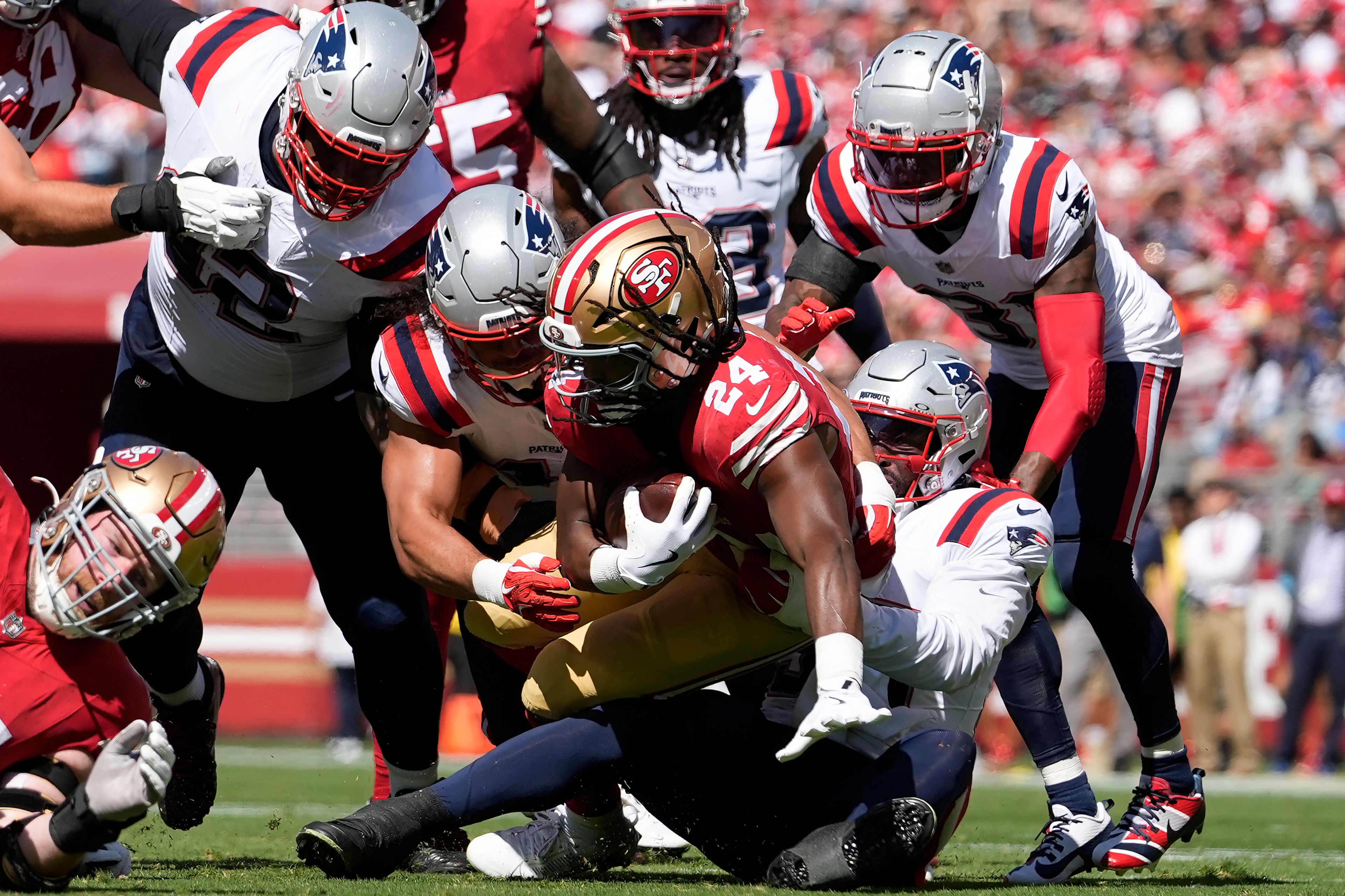 New England Patriots linebacker Joshua Uche, bottom middle right, and teammates tackle San Francisco 49ers running back Jordan Mason (24) during the first half of an NFL football game in Santa Clara, Calif., Sunday, Sept. 29, 2024. (AP Photo/Godofredo A. Vásquez)