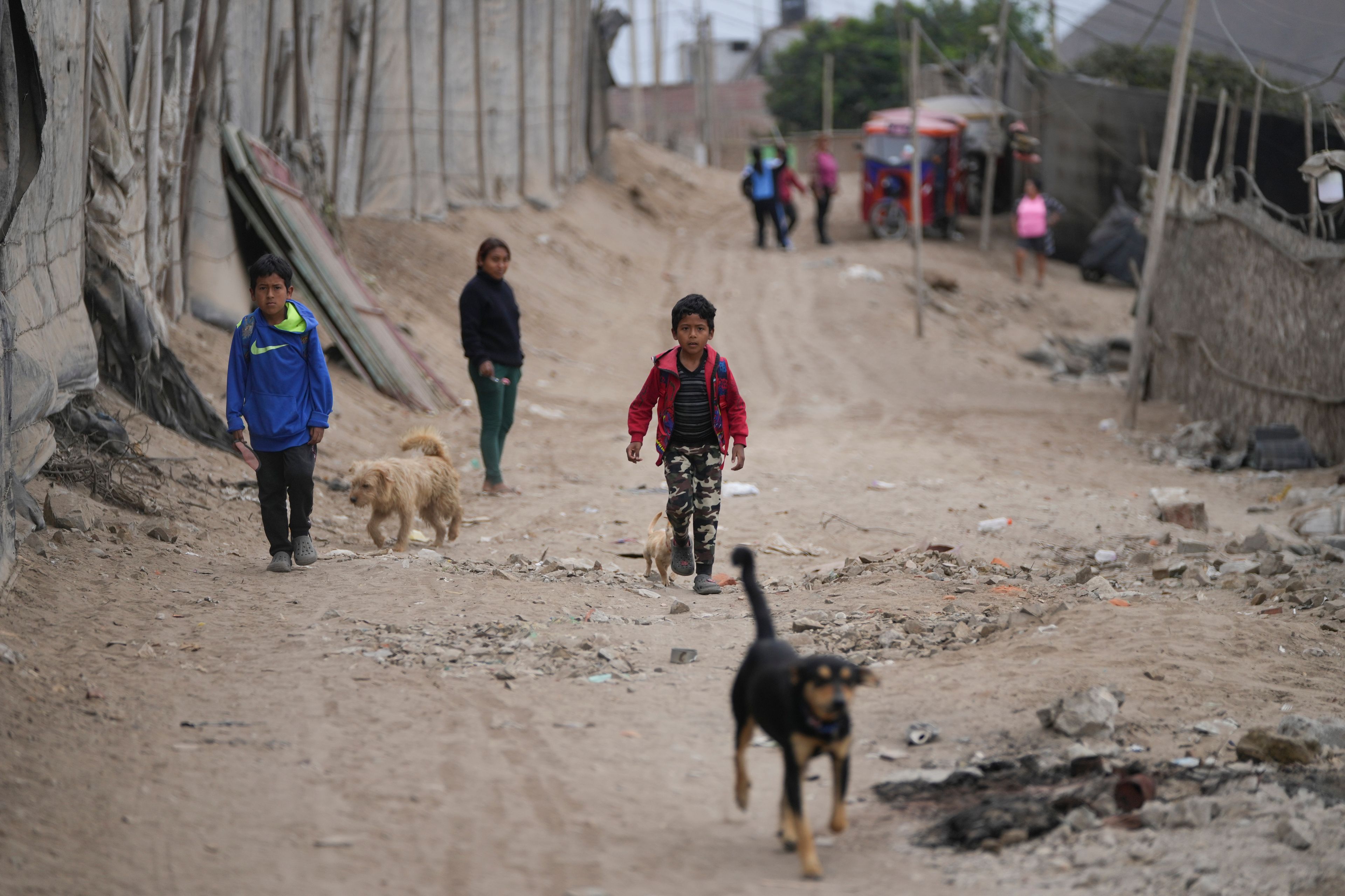 Children walk around in the Senor de la Soledad shantytown near a Chinese-funded port in Chancay, Peru, Tuesday, Nov. 12, 2024. (AP Photo/Silvia Izquierdo)