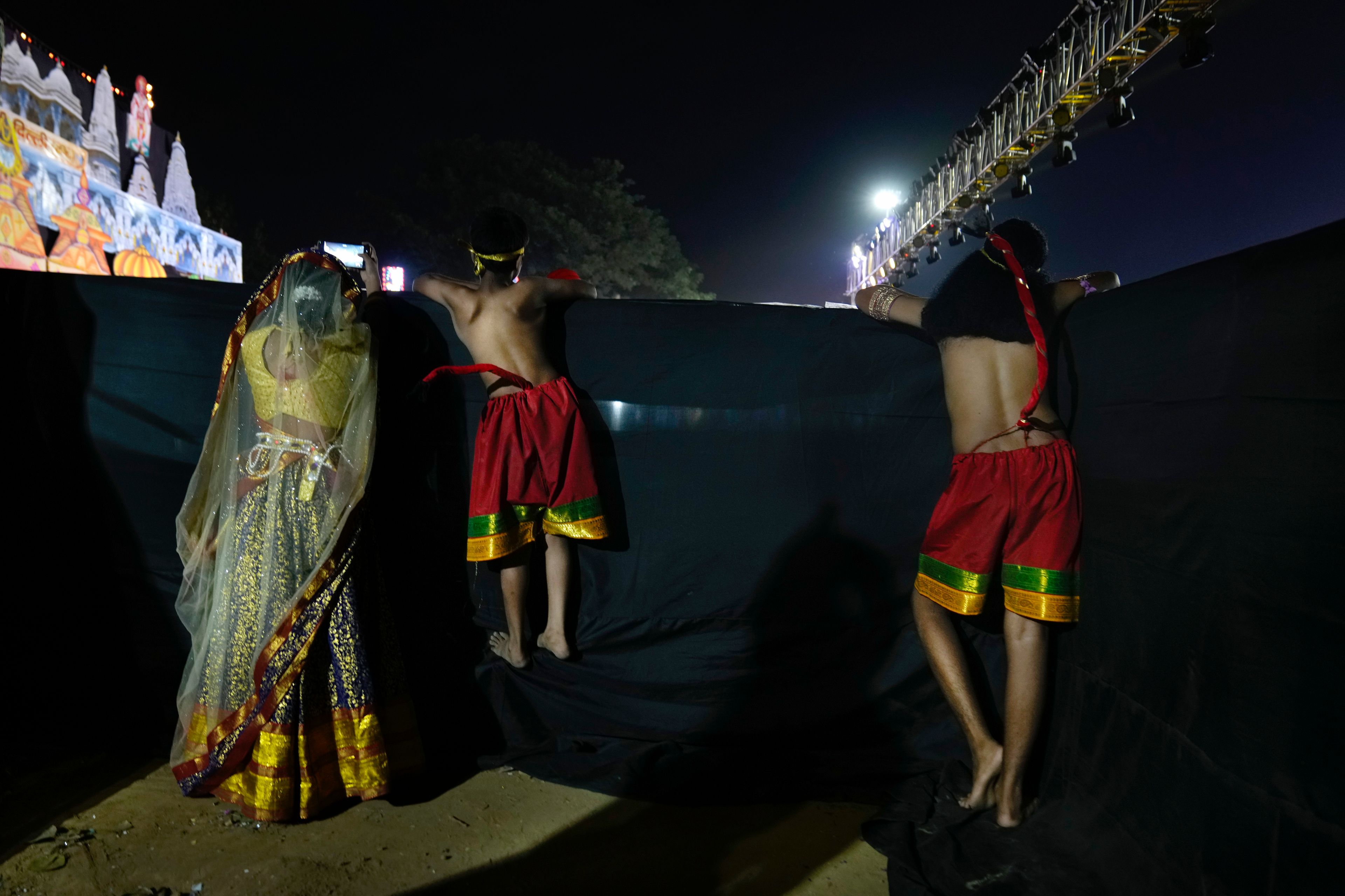 Children performing the characters of foot soldiers in Vanar Sena, or monkey brigade, wait backstage for their turn to perform in Ramleela, a dramatic folk re-enactment of the life of Hindu god Rama according to the ancient Hindu epic Ramayana, in New Delhi, India, Thursday, Oct. 10, 2024. (AP Photo/Manish Swarup)