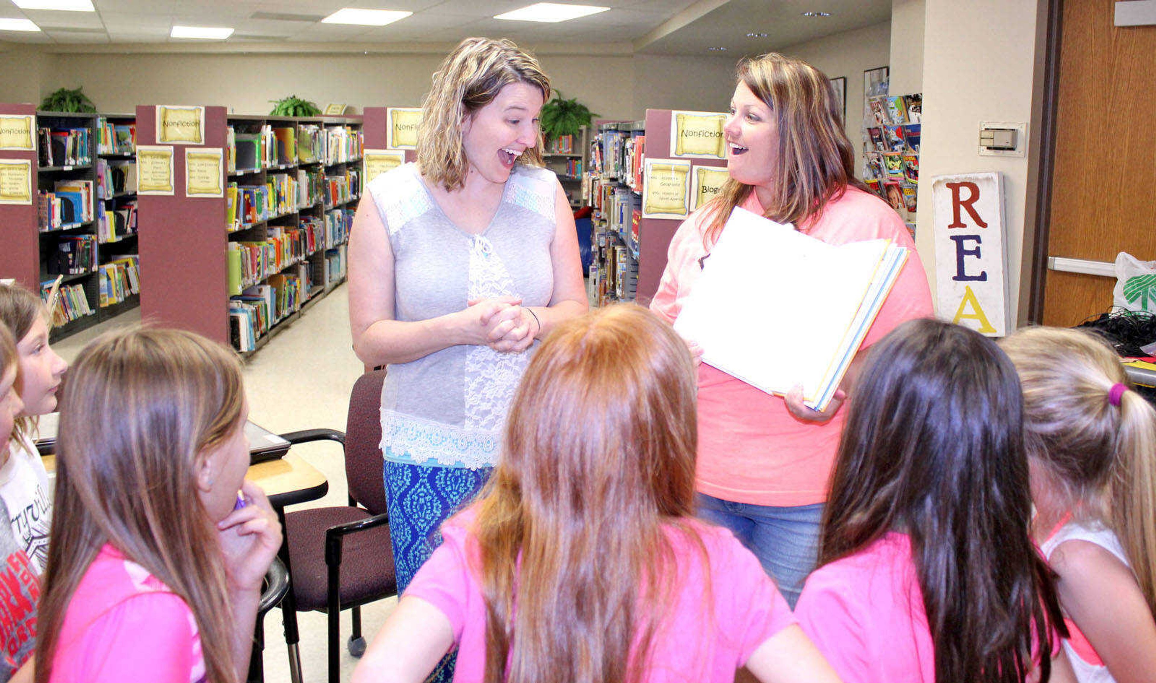 Mrs. Stueve and her students present an autographed copy of “Turkey’s Disguise” to PES librarian Mrs. Michelle House.