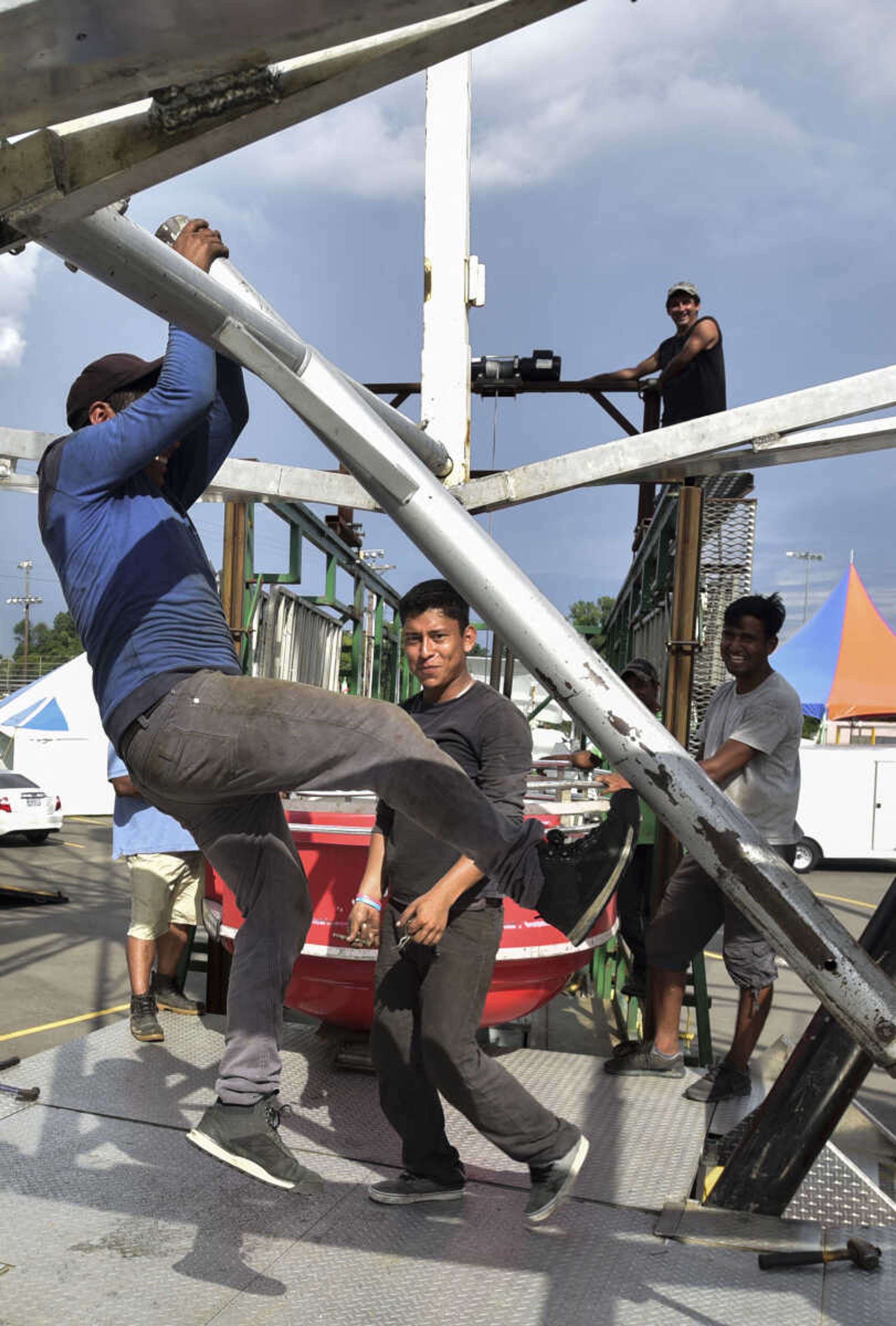 Carnival workers attach ferris wheel cars at the SEMO District Fairgrounds on Thursday, Sept. 6, 2018, in Cape Girardeau.