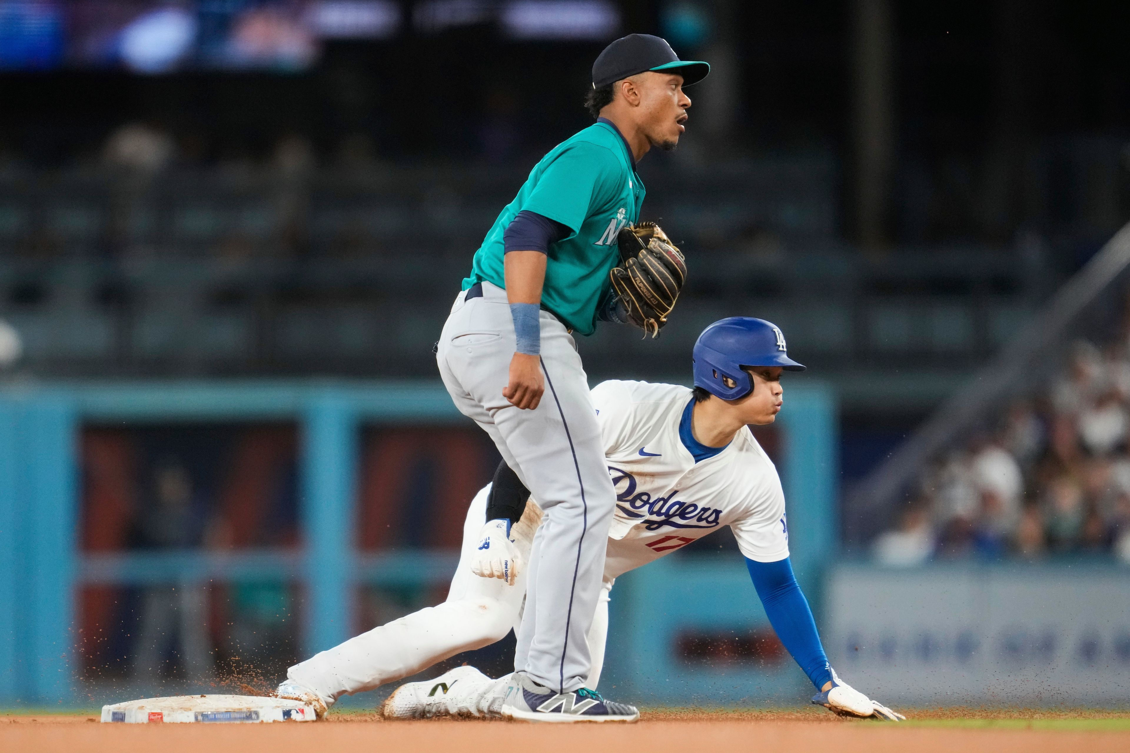 Los Angeles Dodgers designated hitter Shohei Ohtani (17) steals second base during the fifth inning of a baseball game against the Seattle Mariners in Los Angeles, Wednesday, Aug. 21, 2024. (AP Photo/Ashley Landis)