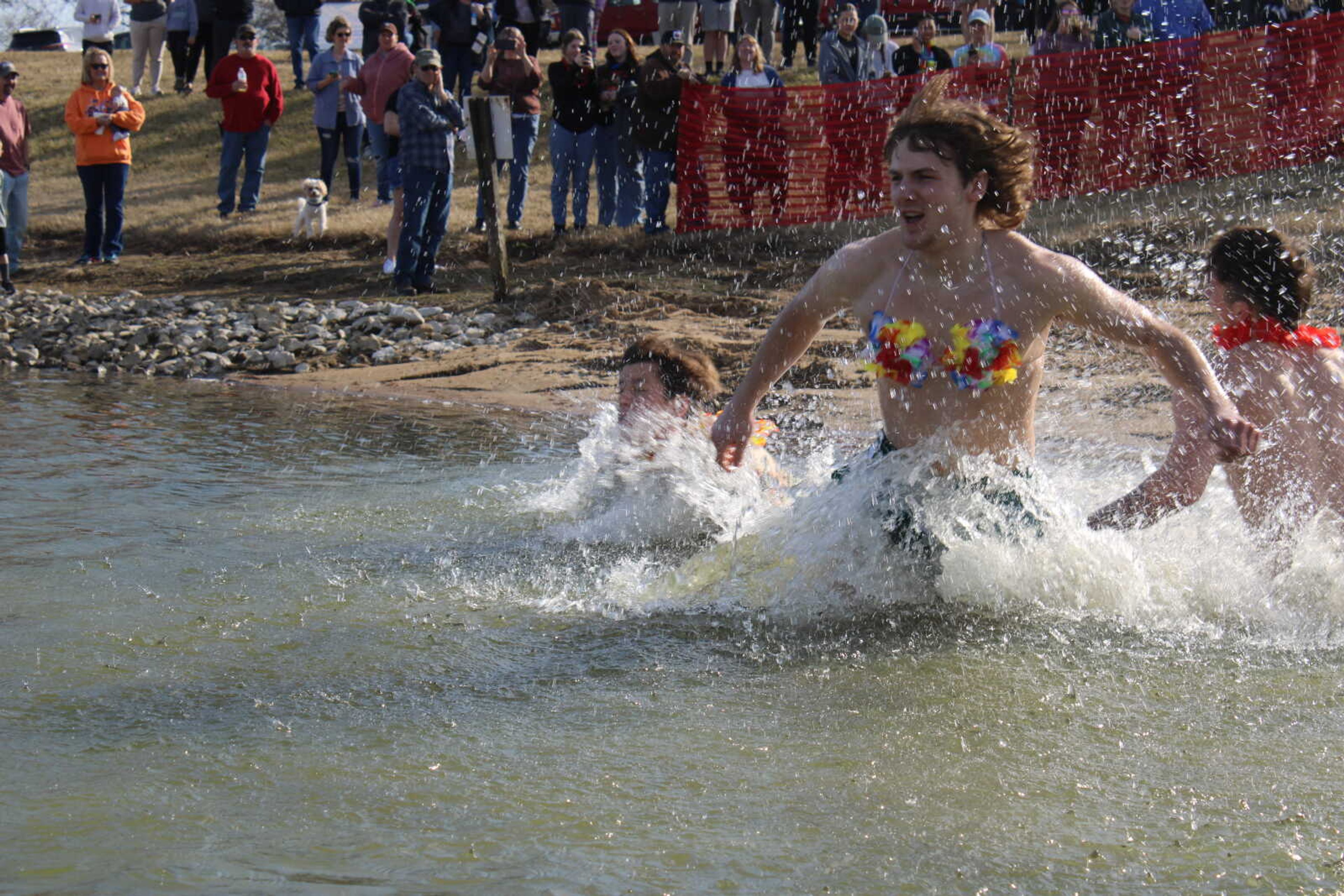 Adam Swinford takes a running start into the pond during the Polar Plunge