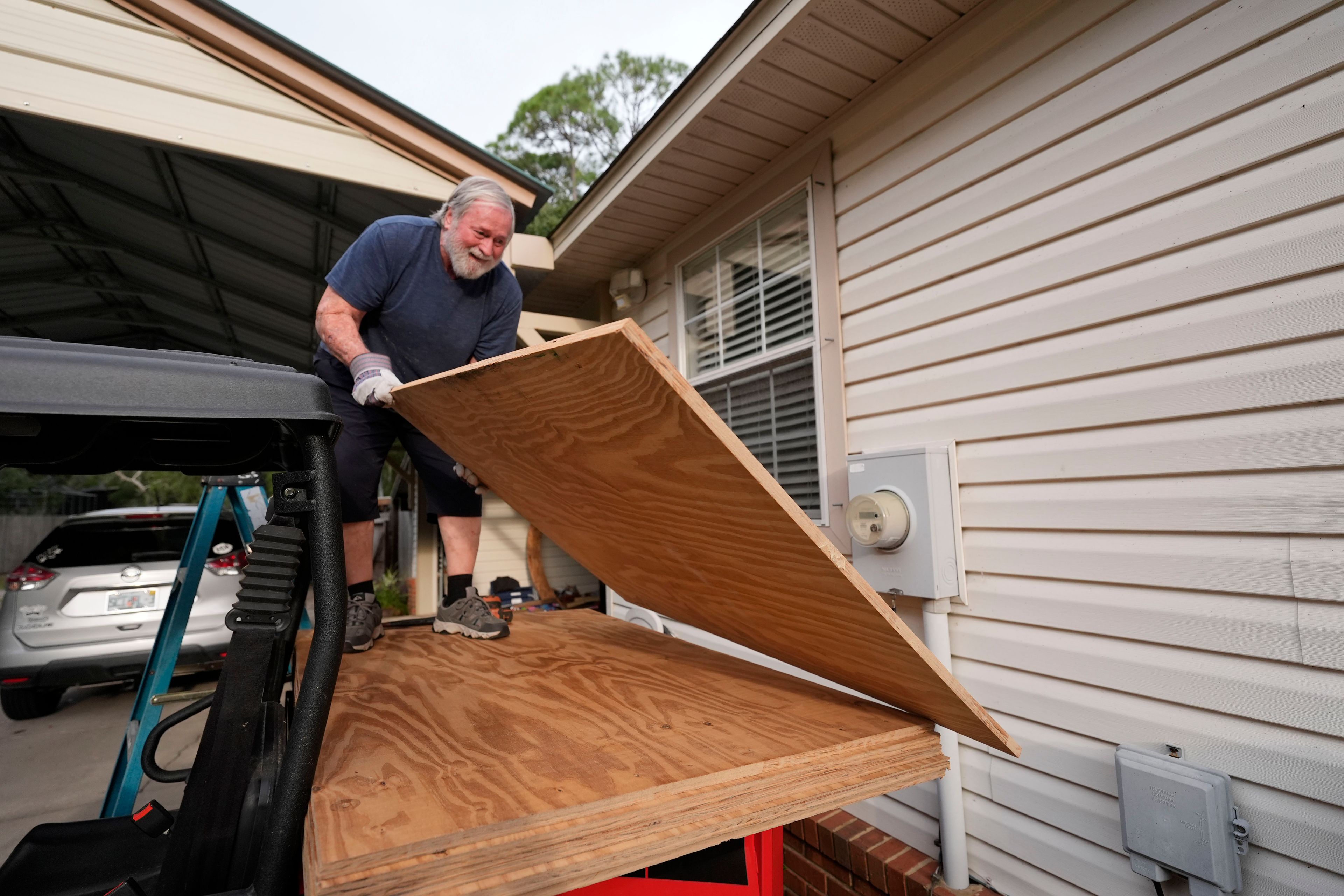 Dave McCurley boards up the windows to his home in advance of Tropical Storm Helene, expected to make landfall as a hurricane, in Ochlockonee Bay, Fla., Wednesday, Sept. 25, 2024. (AP Photo/Gerald Herbert)