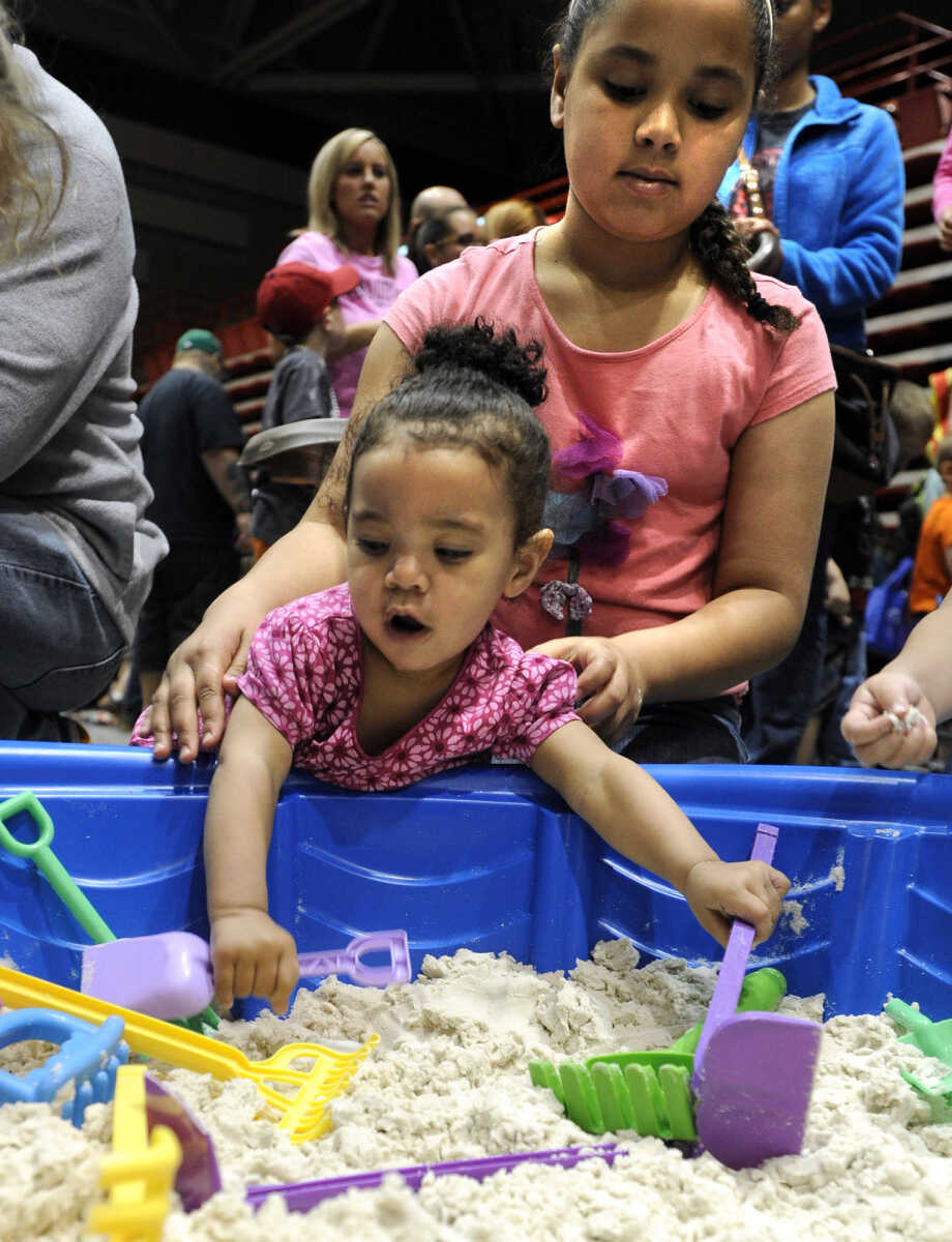 Bethani Robinson enjoys playing in dough as Talia Bowman assists her at the Messy Morning event Saturday, April 25, 2015 at the Show Me Center.