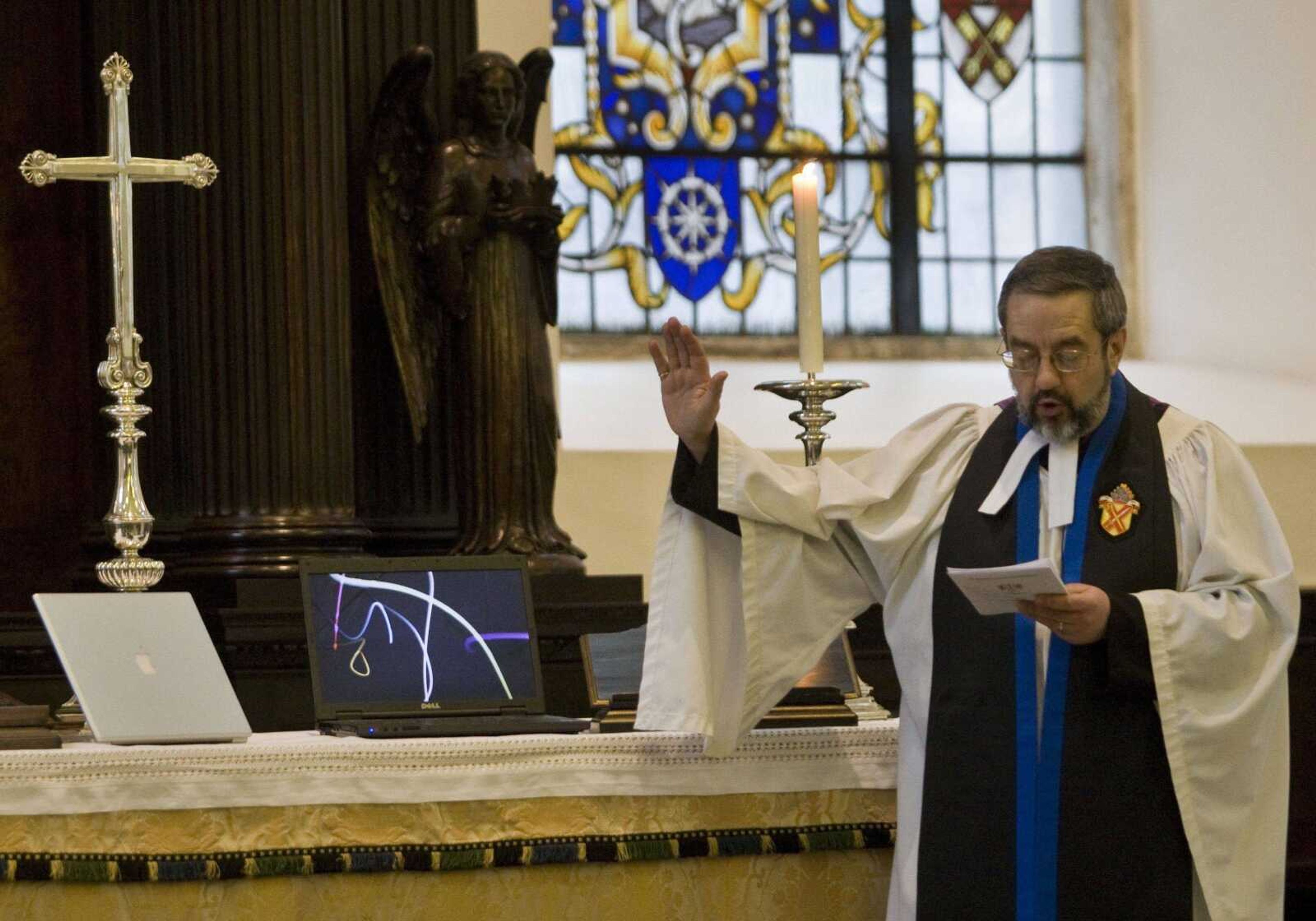 The Rev. Canon David Parrott blesses computers and mobile phones Monday on the altar of the St. Lawrence Jewry church in London. Parrott performed the blessing in an effort, he said, to remind the capital's busy office workers that God's grace can reach them in many ways. (Sang Tan ~ Associated Press)