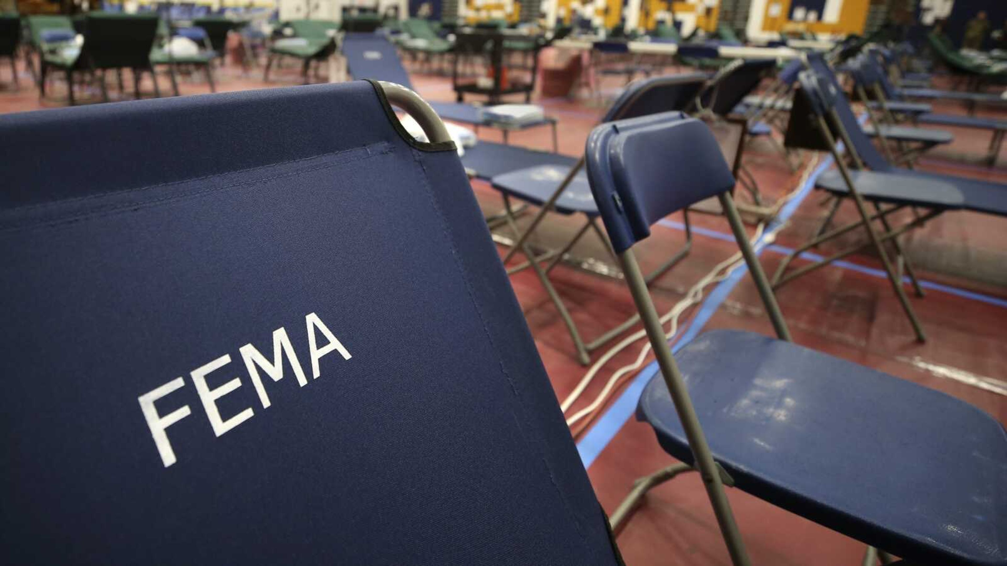 A portable cot, with the Federal Emergency Management Agency logo "FEMA" printed on the backrest, and other cots line the basketball court at a makeshift medical facility in a gymnasium at Southern New Hampshire University on March 24, 2020, in Manchester, New Hampshire. FEMA may have been double-billed for the funerals of hundreds of people who died of COVID-19, the Government Accountability Office said in a new report Wednesday.