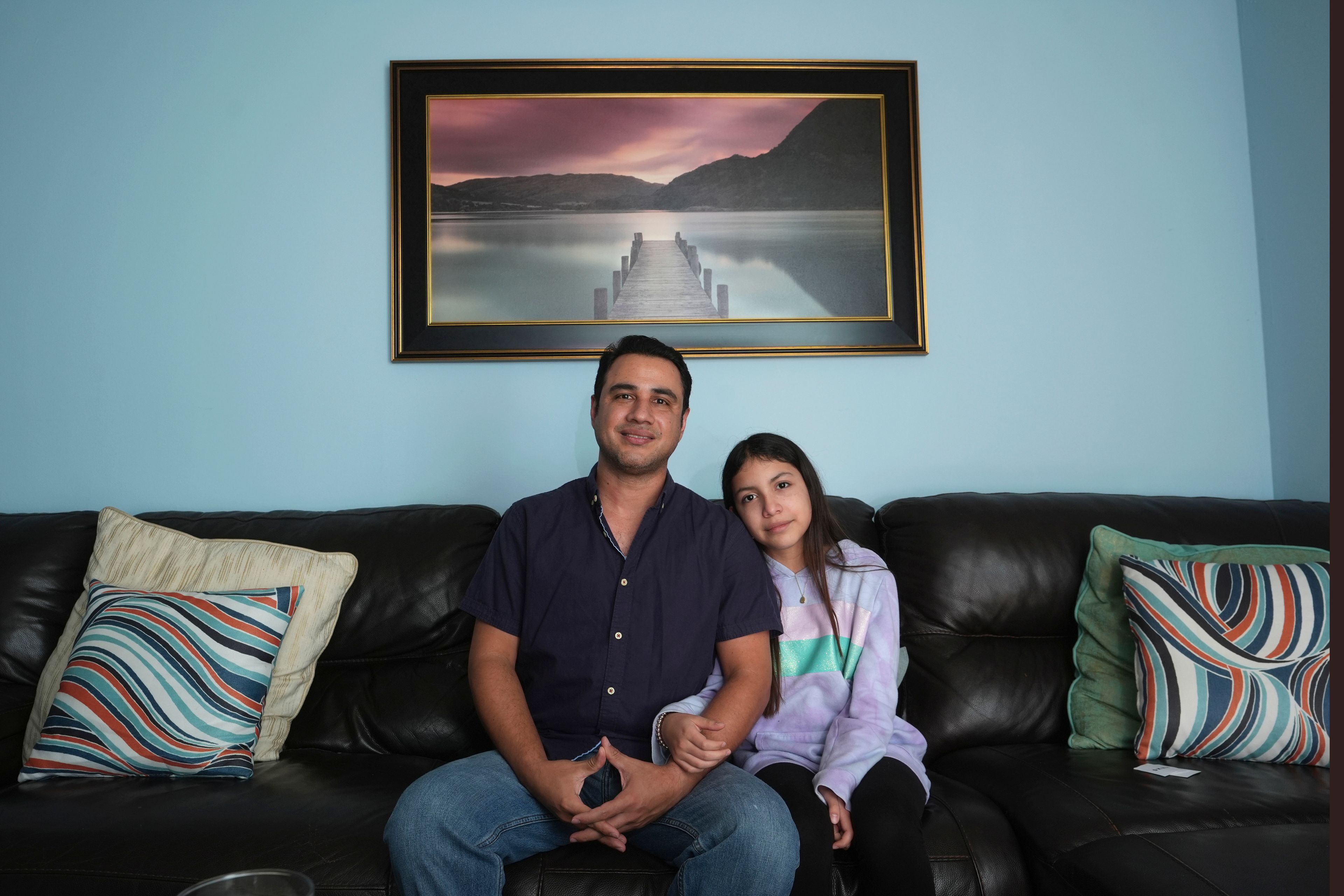 Manuel Castano, a 39-year-old human rights activist from Nicaragua who works in building maintenance in South Florida, and his daughter Emily, 13 pose for a photo on Monday, Nov. 11, 2024, at their home in Miami. (AP Photo/Wilfredo Lee)