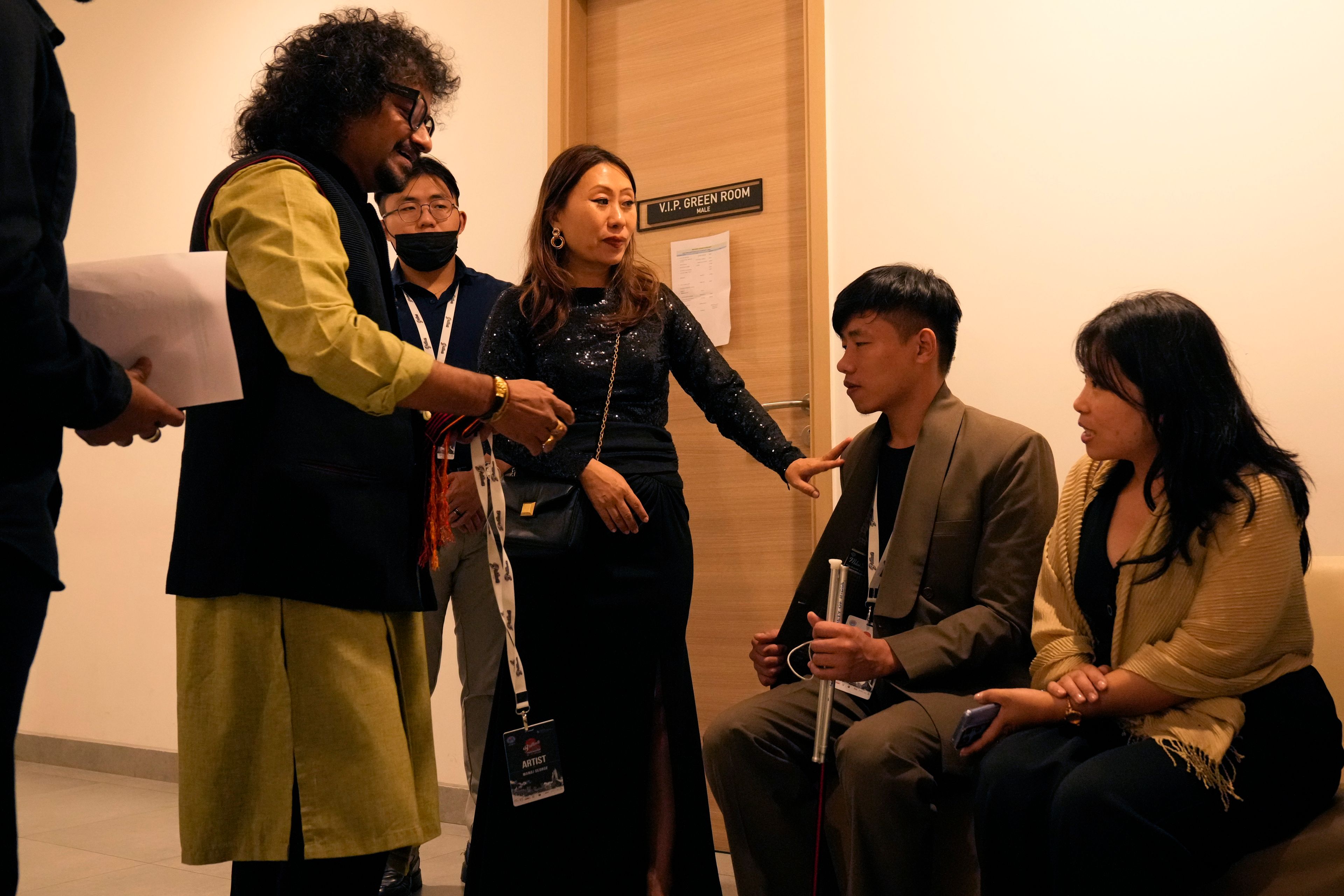 Takosangba Jamir, 27, a blind pianist, second right, is introduced to other artists by festival director Khyochano TCK, center, as he waits backstage for his performance at the two-day Brillante Piano Festival in Bengaluru, India, Sunday, Sept. 29, 2024. (AP Photo/Aijaz Rahi)