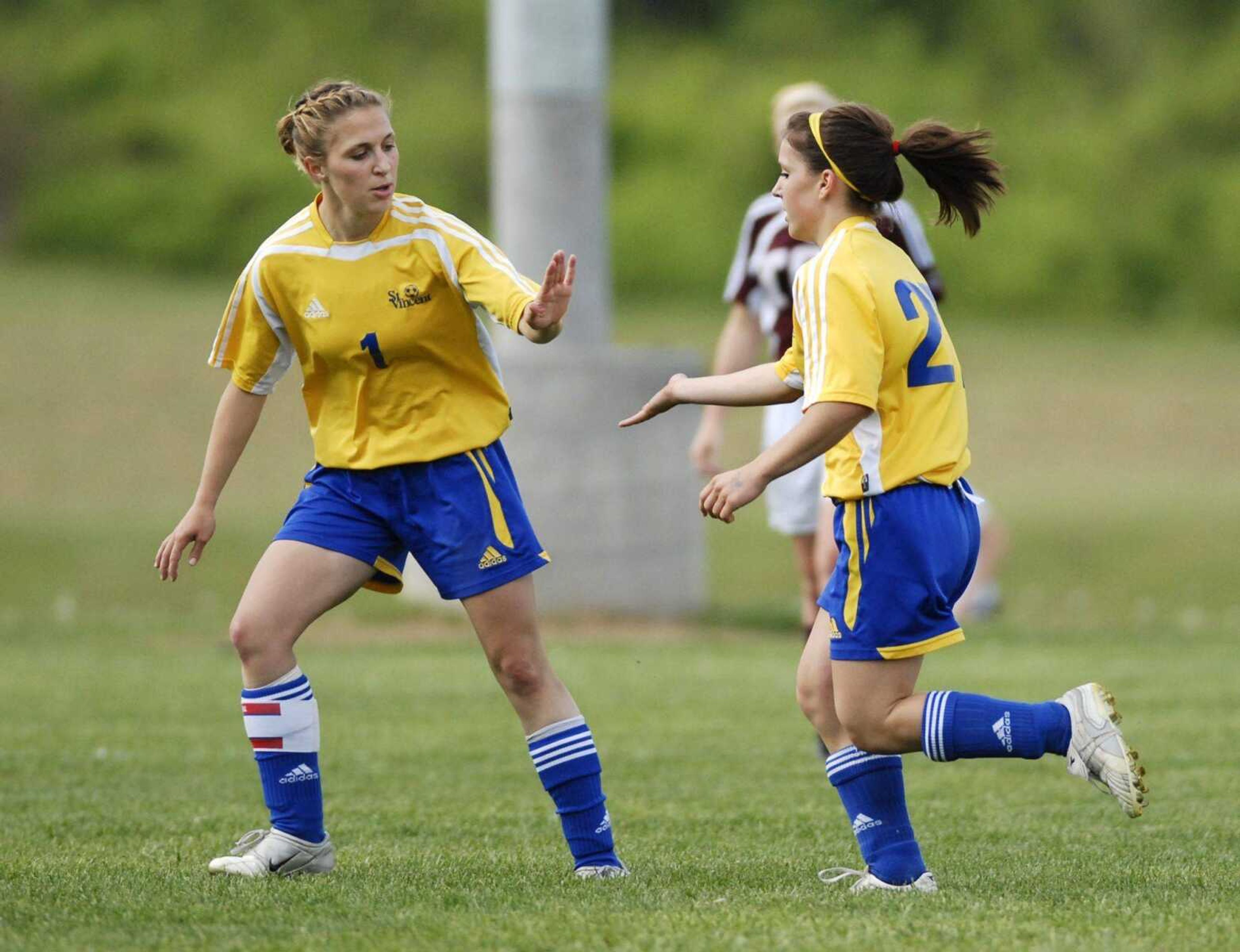 St. Vincent senior Liz Brueckner, left, congratulates teammate Abby Lappe after Lappe scored the team's first goal during Friday's game. St. Vincent won a rematch of last year's Class 1 state championship game 3-1.