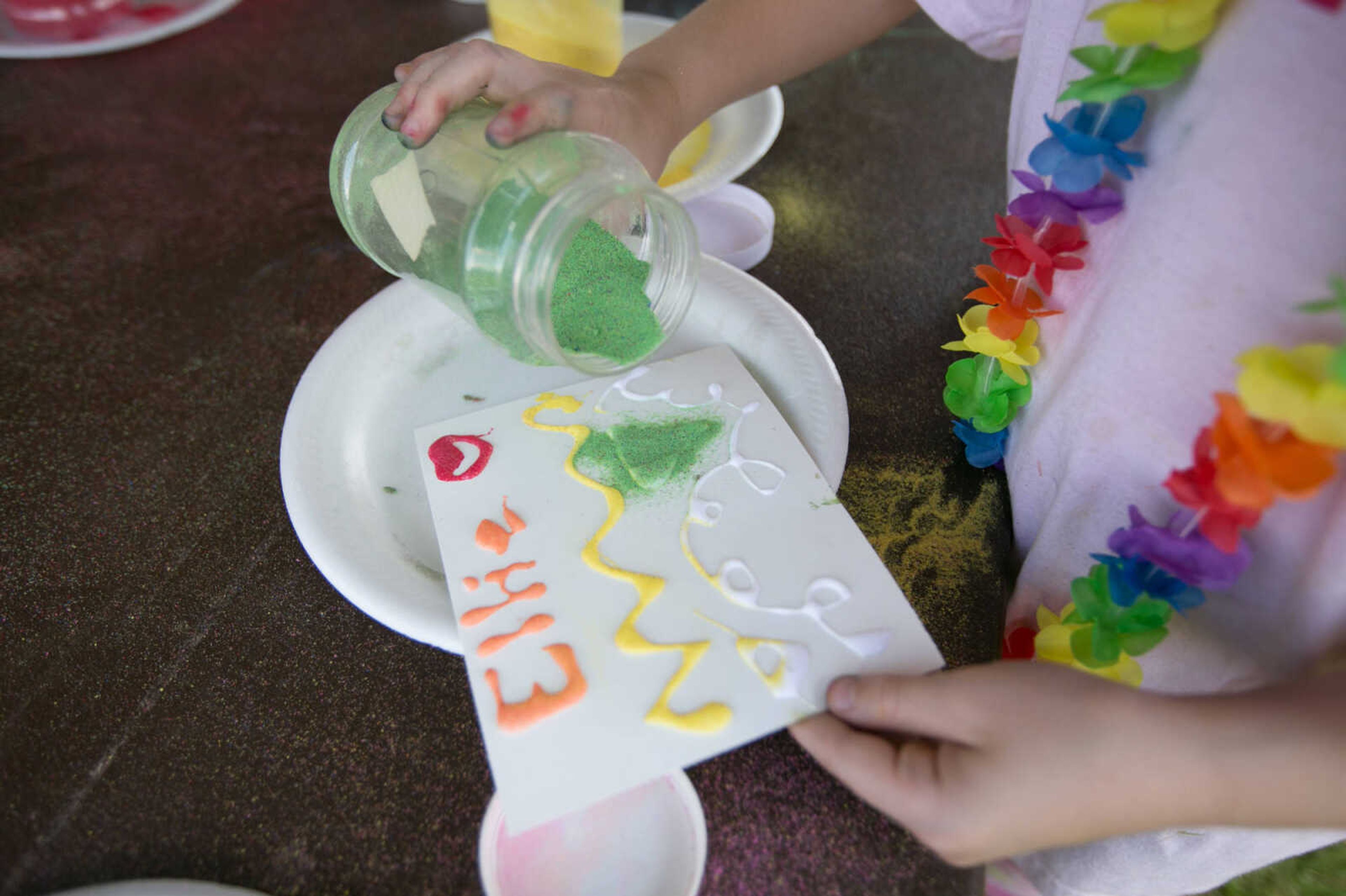 GLENN LANDBERG ~ glandberg@semissourian.com

Ellie Douglass sprinkles colored sand while creating art Saturday, June 18, 2016 at the River Campus Summer Arts Festival.