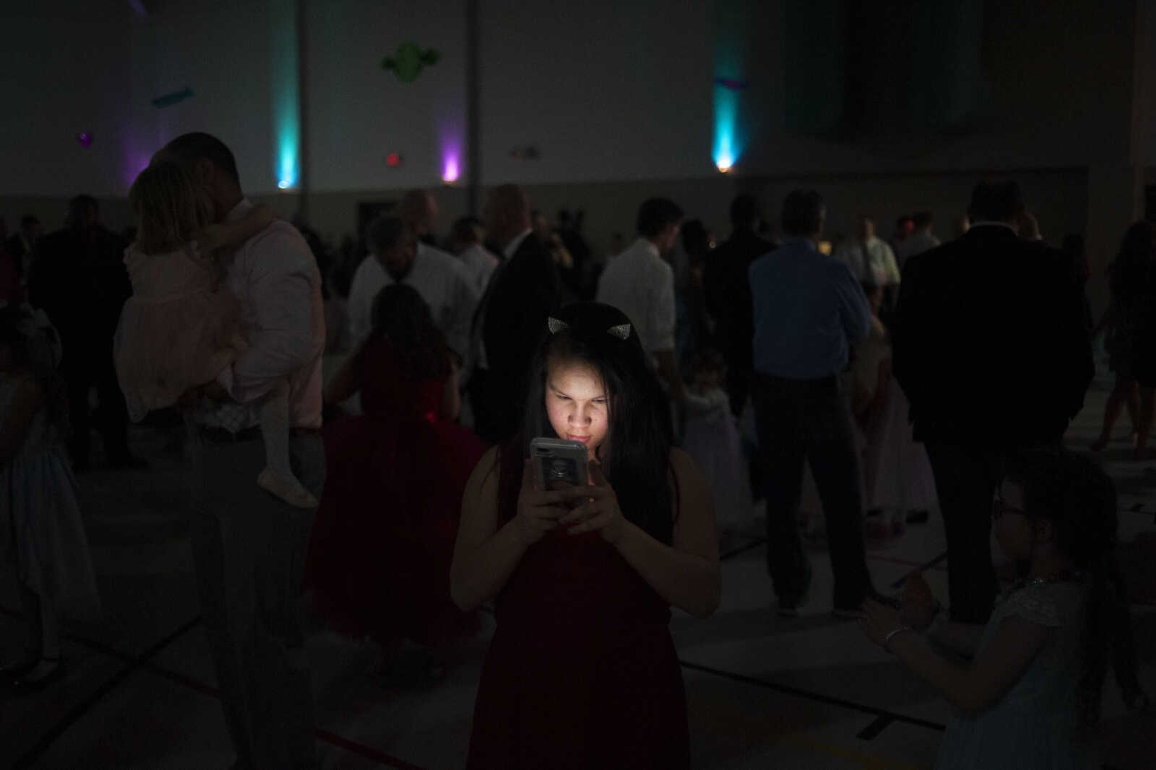 Jennifer Groves of Scott City, 14, looks at a phone during the 11th annual Father Daughter Dance on Saturday, Feb. 16, 2019, at Osage Centre in Cape Girardeau.