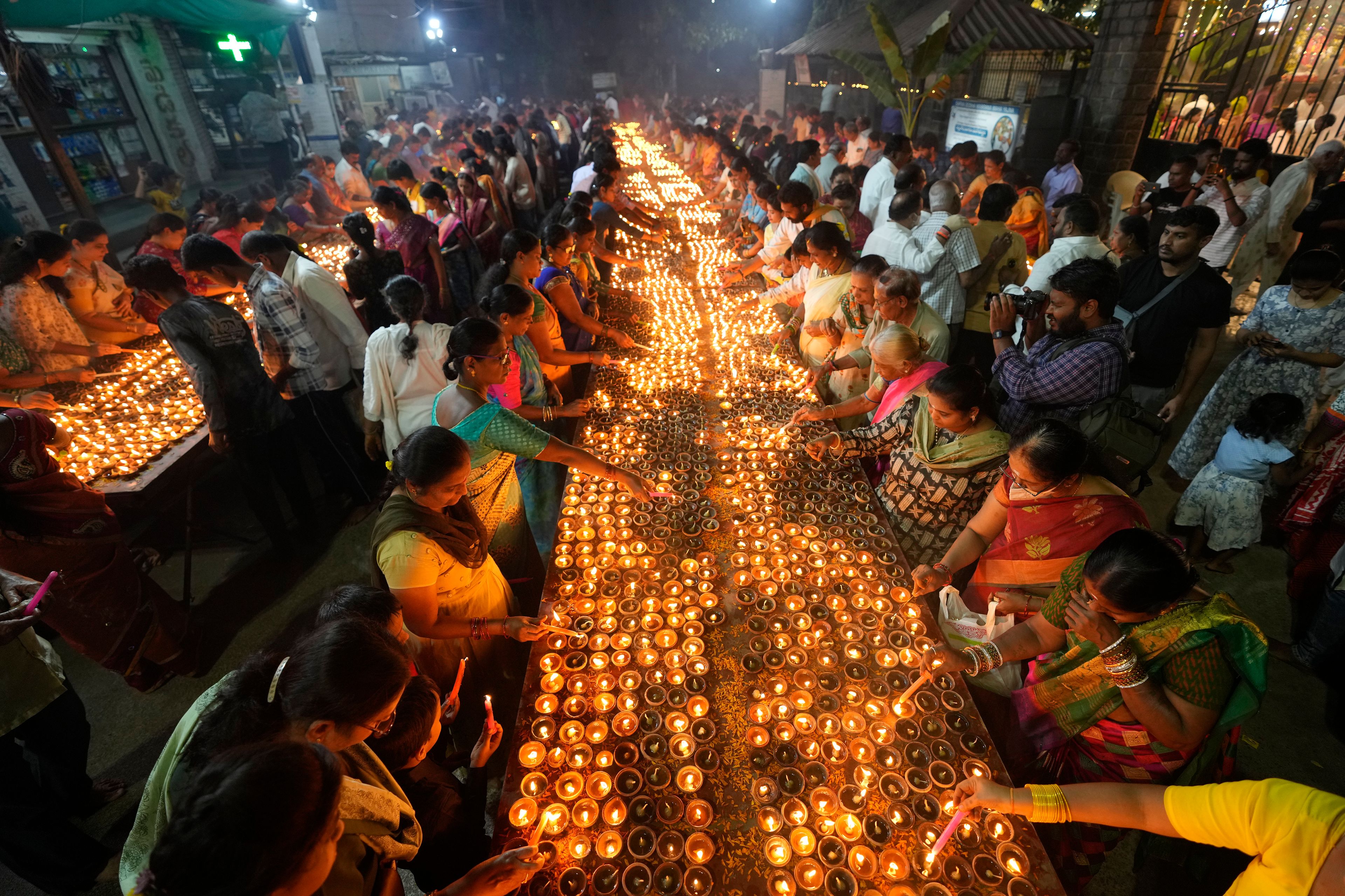 Hindu devotees light earthen lamps at a temple on auspicious day of Karthik Purnima, which is celebrated on full moon day of the Hindu calendar month "Karthika", in Hyderabad, India, Friday, Nov. 15, 2024. (AP Photo/Mahesh Kumar A.)