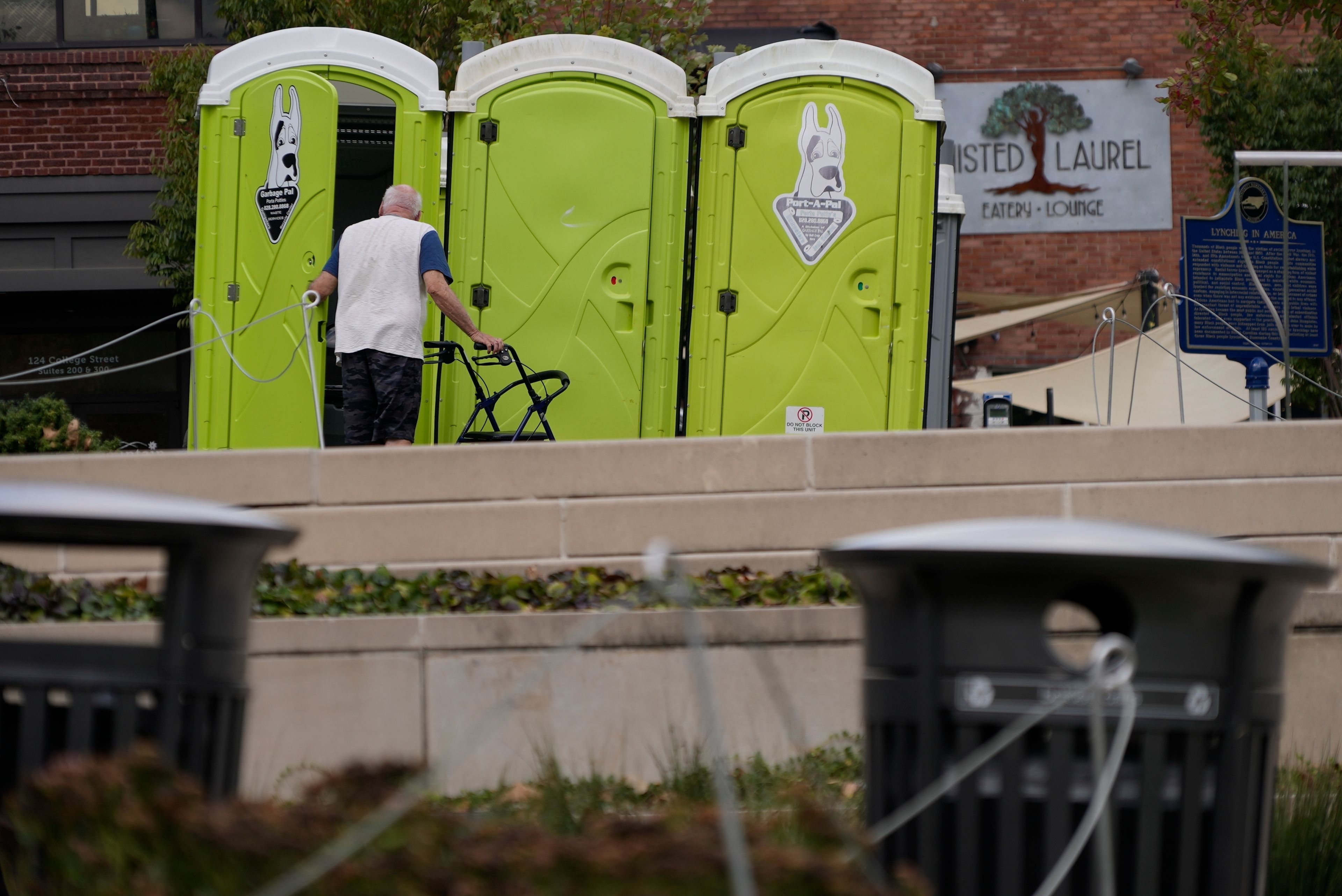 People use public toilets where there has been no water for the week since Hurricane Helene struck the region and damaged critical infrastructure, Thursday, Oct. 3, 2024 in Asheville, N.C. (AP Photo/Brittany Peterson)