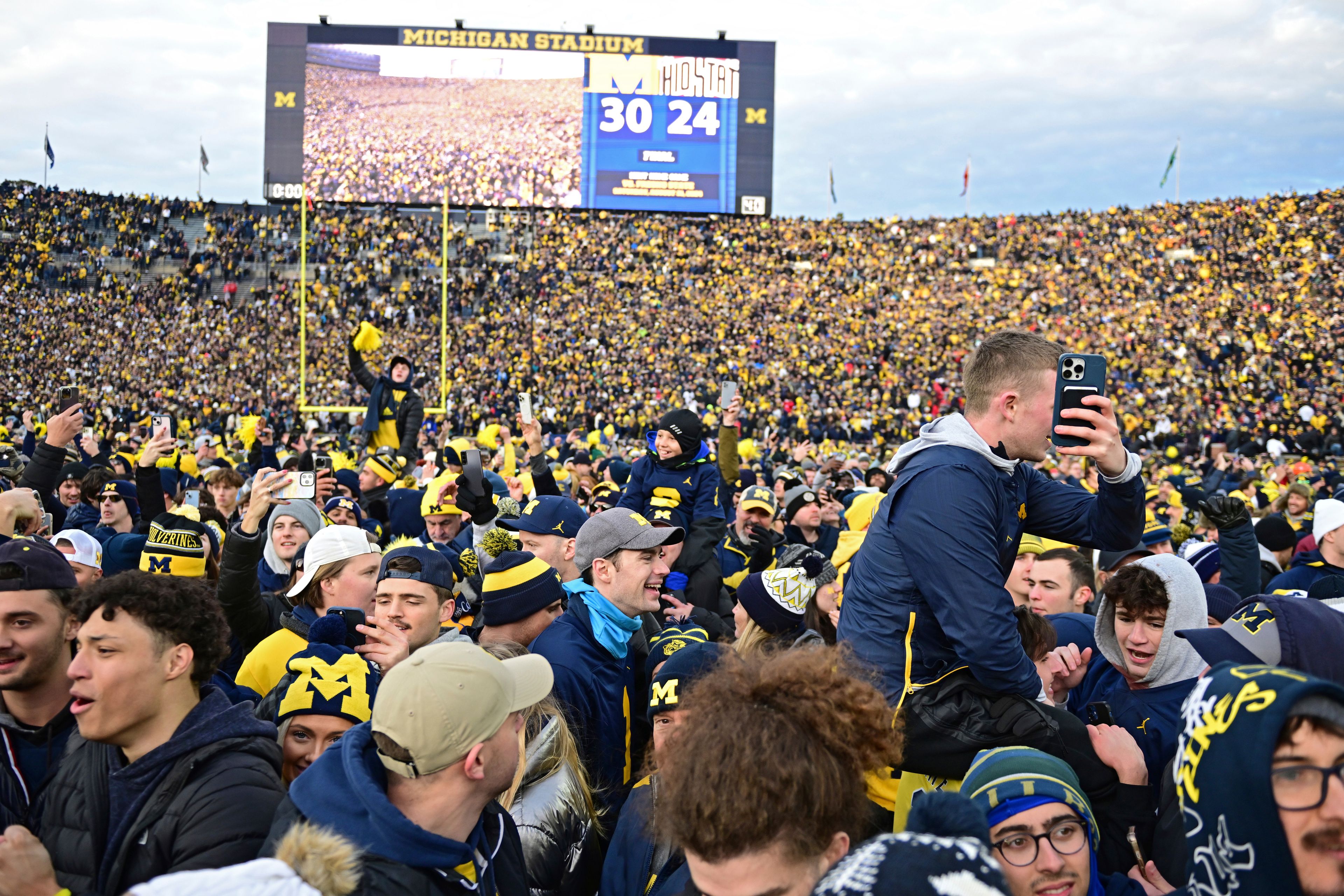 FILE - Fans rush the field after Michigan defeated Ohio State 30-24 in an NCAA college football game, Saturday, Nov. 25, 2023, in Ann Arbor, Mich. (AP Photo/David Dermer)