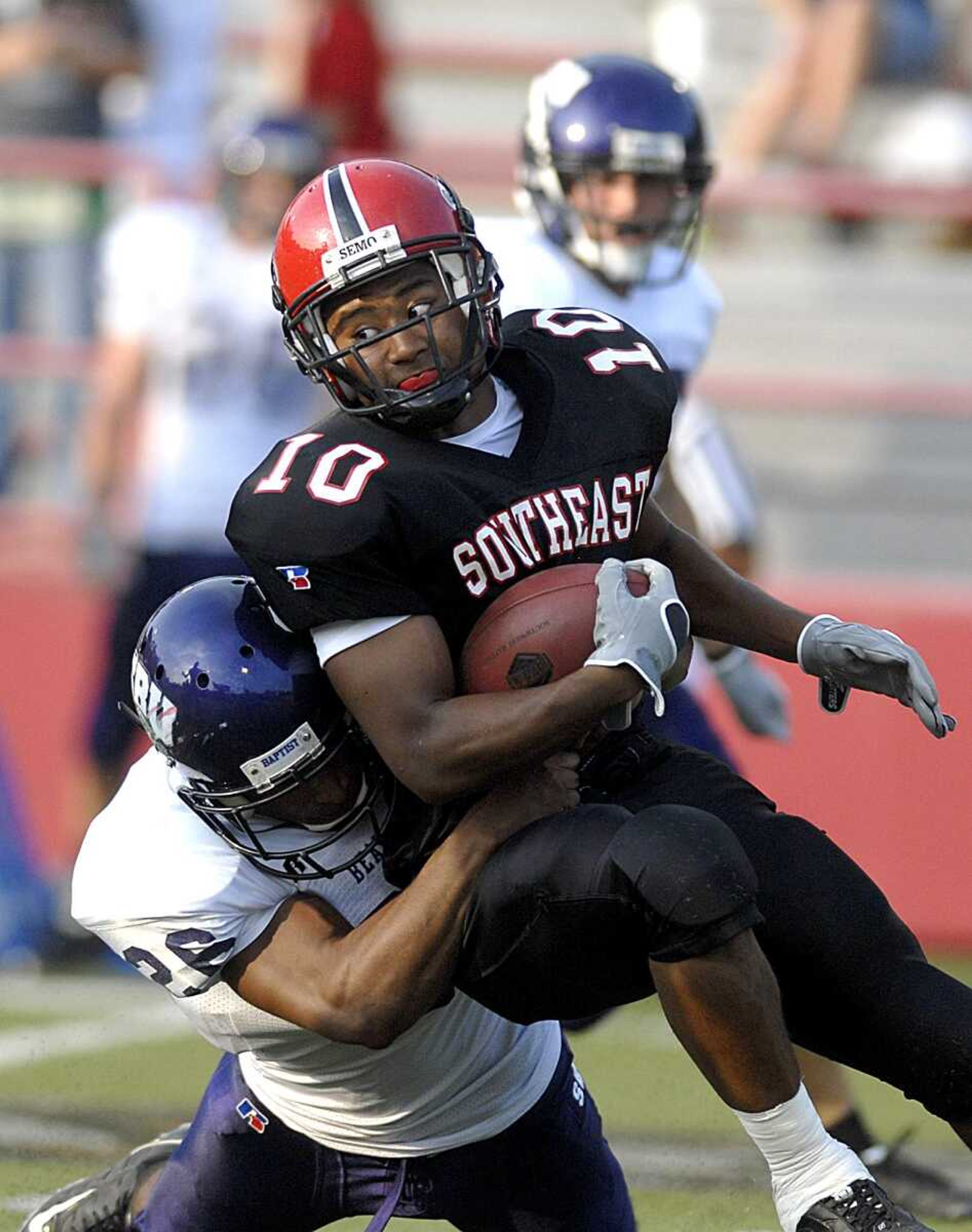 AARON EISEHAUER ~ aeisenhauer@semissourian.com
Southeast's Jacob McKinley is pulled down by Southwest Baptist's Chris Green during the first half on Thursday, August 28, 2008.