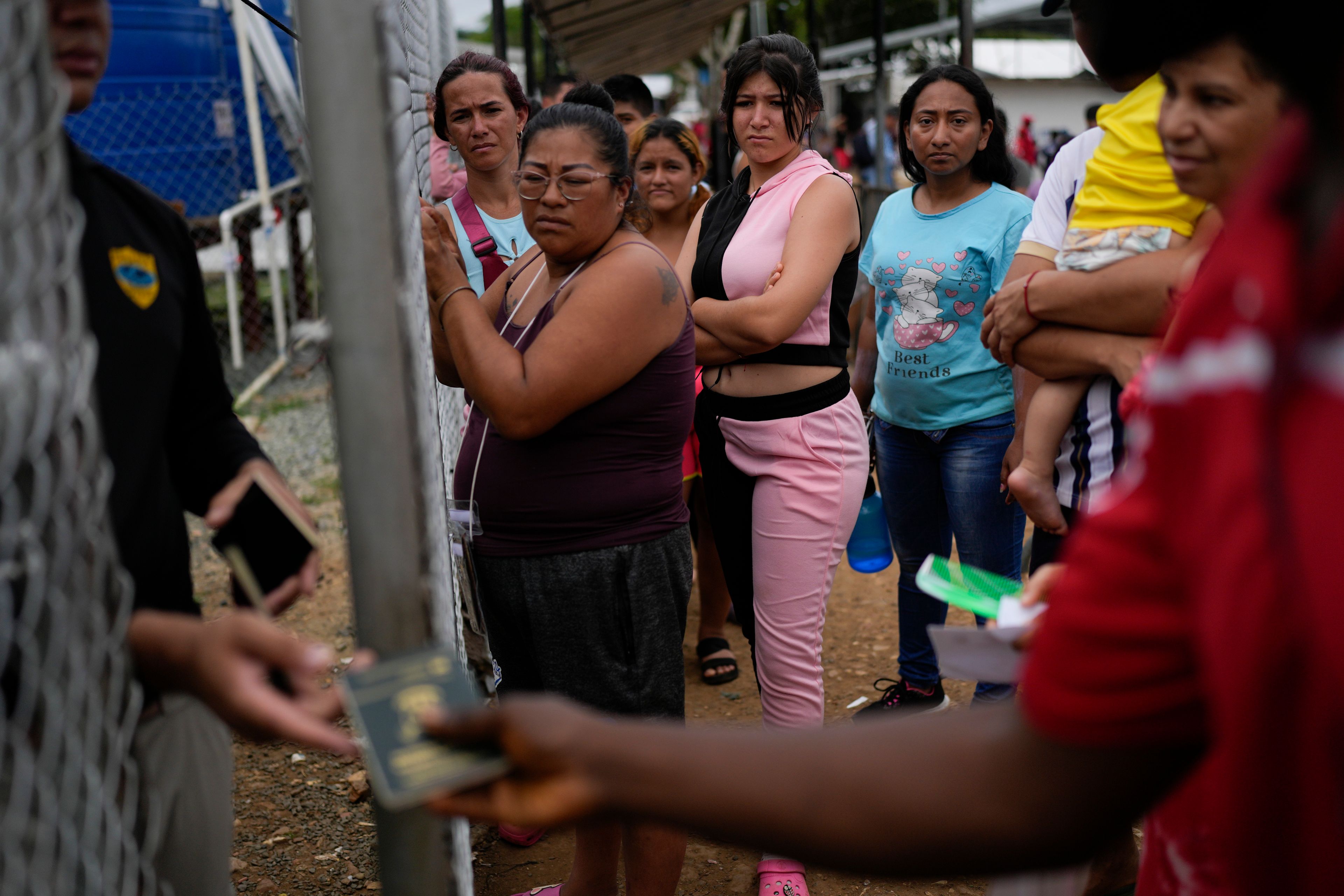 Migrants wait to get back their passports as Panamanian immigration officers process their identifications at a post where those who trekked across the Darién Gap stop along their way north toward the U.S., in Lajas Blancas, Panama, Thursday, Sept. 26, 2024. (AP Photo/Matias Delacroix)