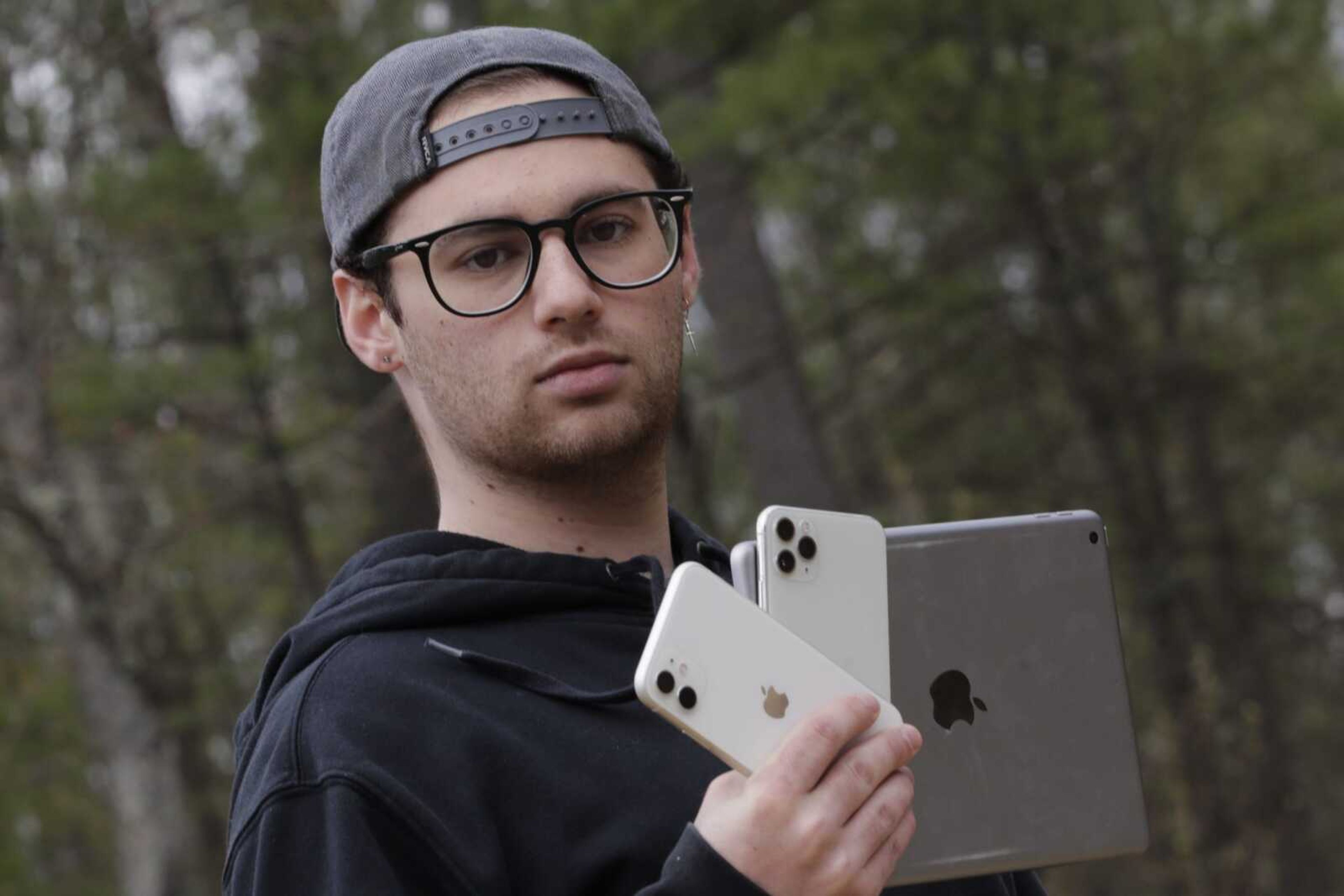 Kaya Suner holds up an iPhone and an iPad as he poses for a portrait May 4 in Northfield, New Hampshire. Suner, whose parents both work as emergency room physicians in Rhode Island, set up a not-for-profit organization with a former classmate that sends donated digital devices to hospitals and long-term care facilities to help patients communicate with loved ones after the coronavirus pandemic eliminated visitations.