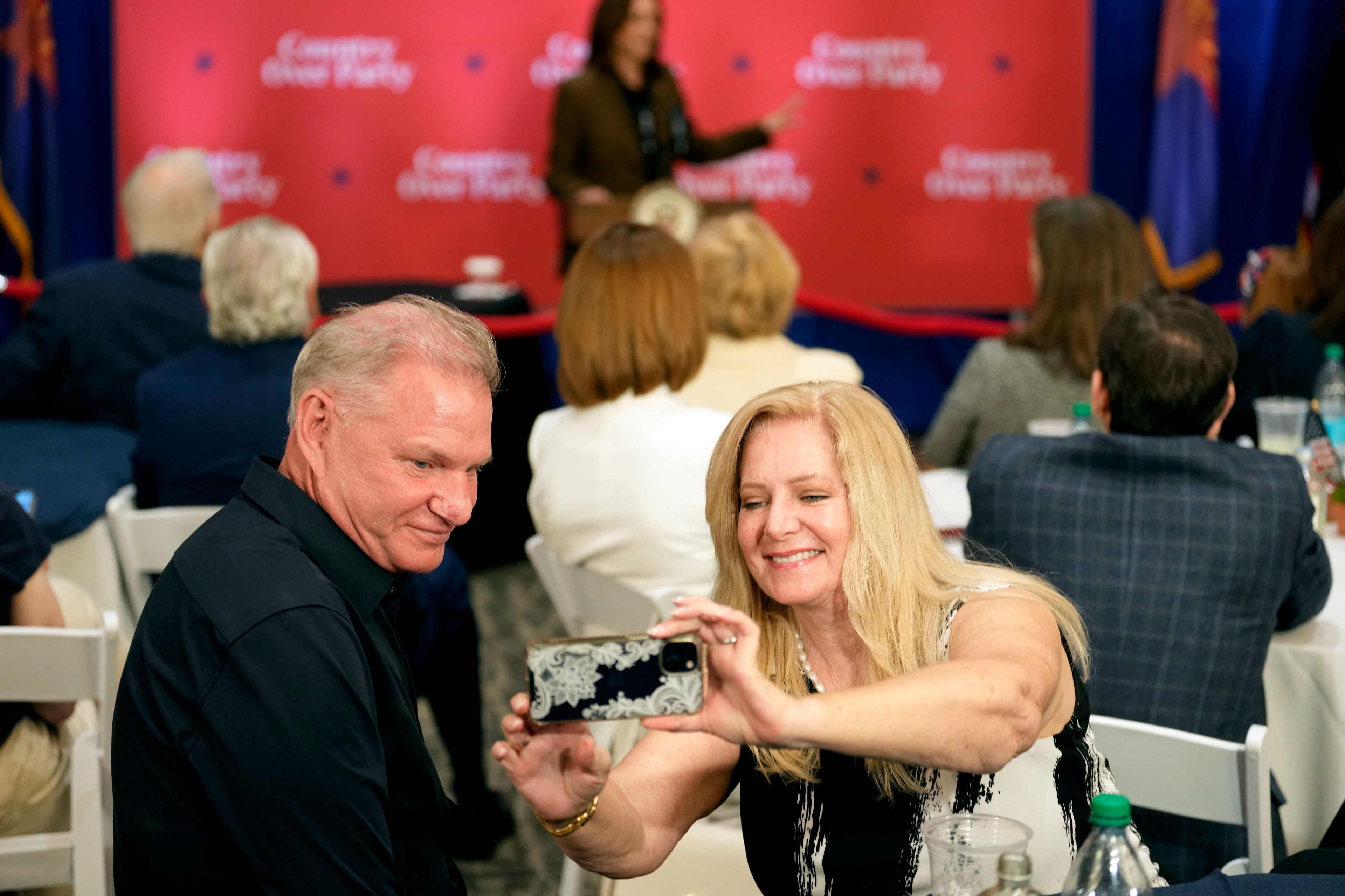 Attendees take a selfie as Democratic presidential nominee Vice President Kamala Harris speaks at a campaign event Friday, Oct. 11, 2024, at the Grayhawk Golf Club in Scottsdale, Ariz. (AP Photo/Ross D. Franklin)