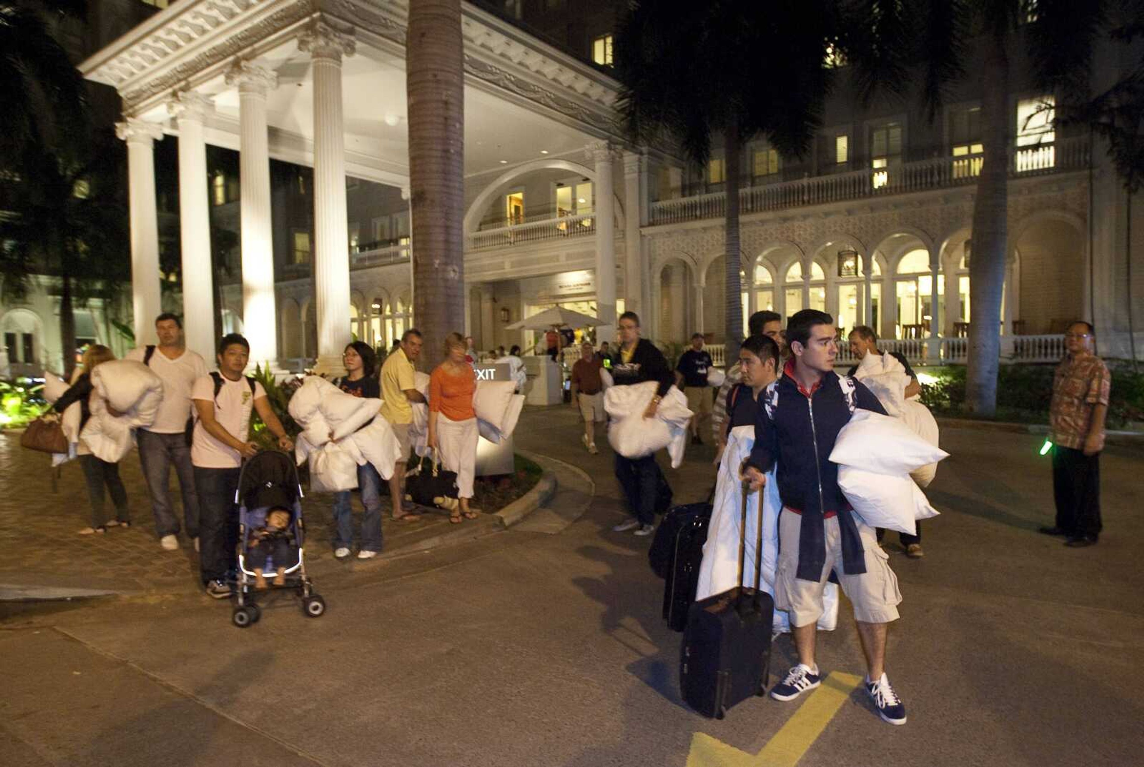 Hotel guests from the Moana Surfrider evacuated early today in Honolulu. The state of Hawaii is under a tsunami warning due to a large 8.9 earthquake which struck off Japan. The earthquake is believed to have generated a tsunami wave. The Pacific Tsunami Center expects the wave to hit Oahu at 3:21 a.m. Hawaiian Standard Time. (AP Photo/Eugene Tanner)