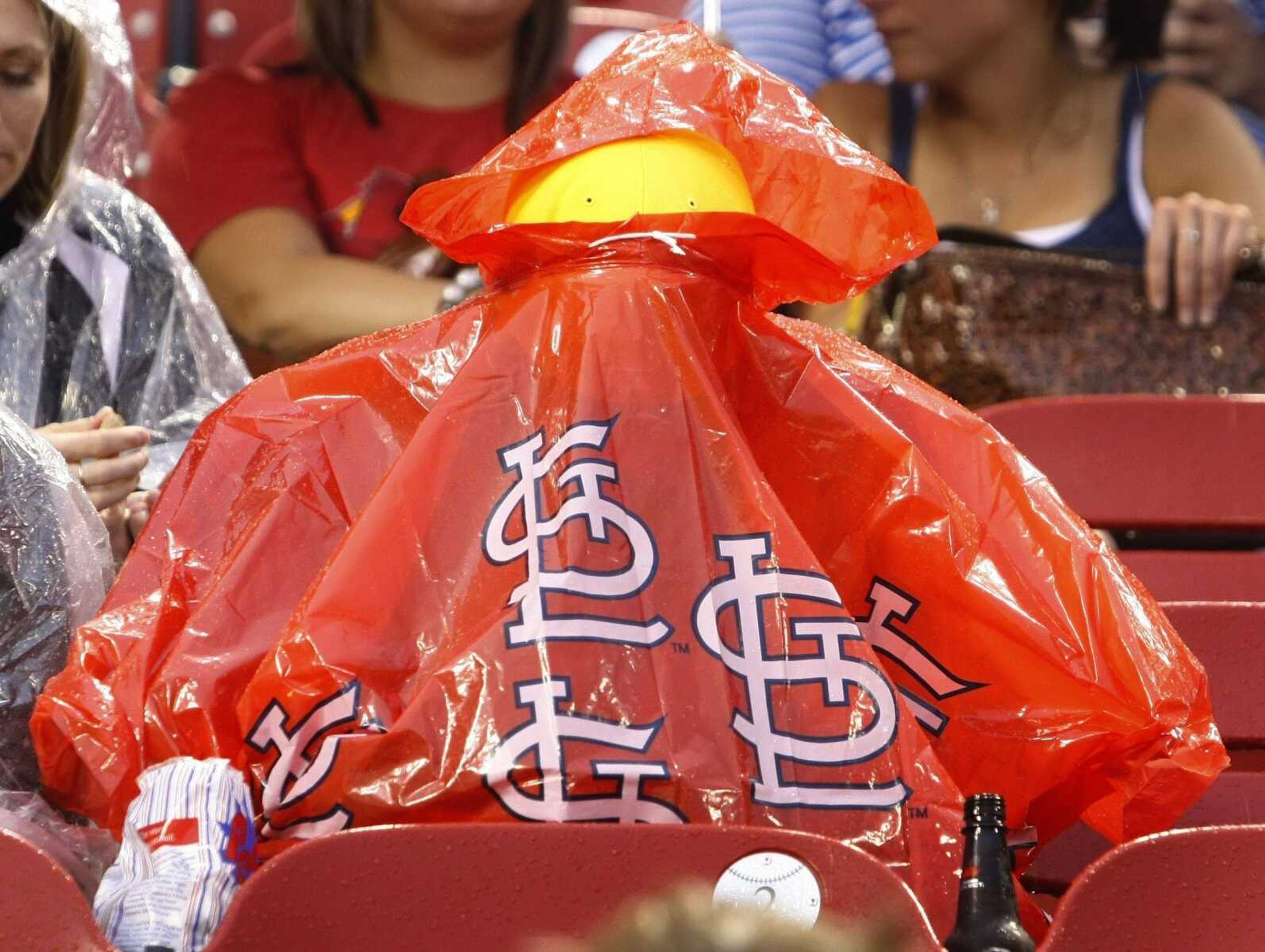 A St. Louis Cardinals fan keeps dry during a rain delay before the start of the Cardinals' baseball game against the Los Angeles Dodgers, Tuesday, July 28, 2009, in St. Louis. (AP Photo/Tom Gannam)