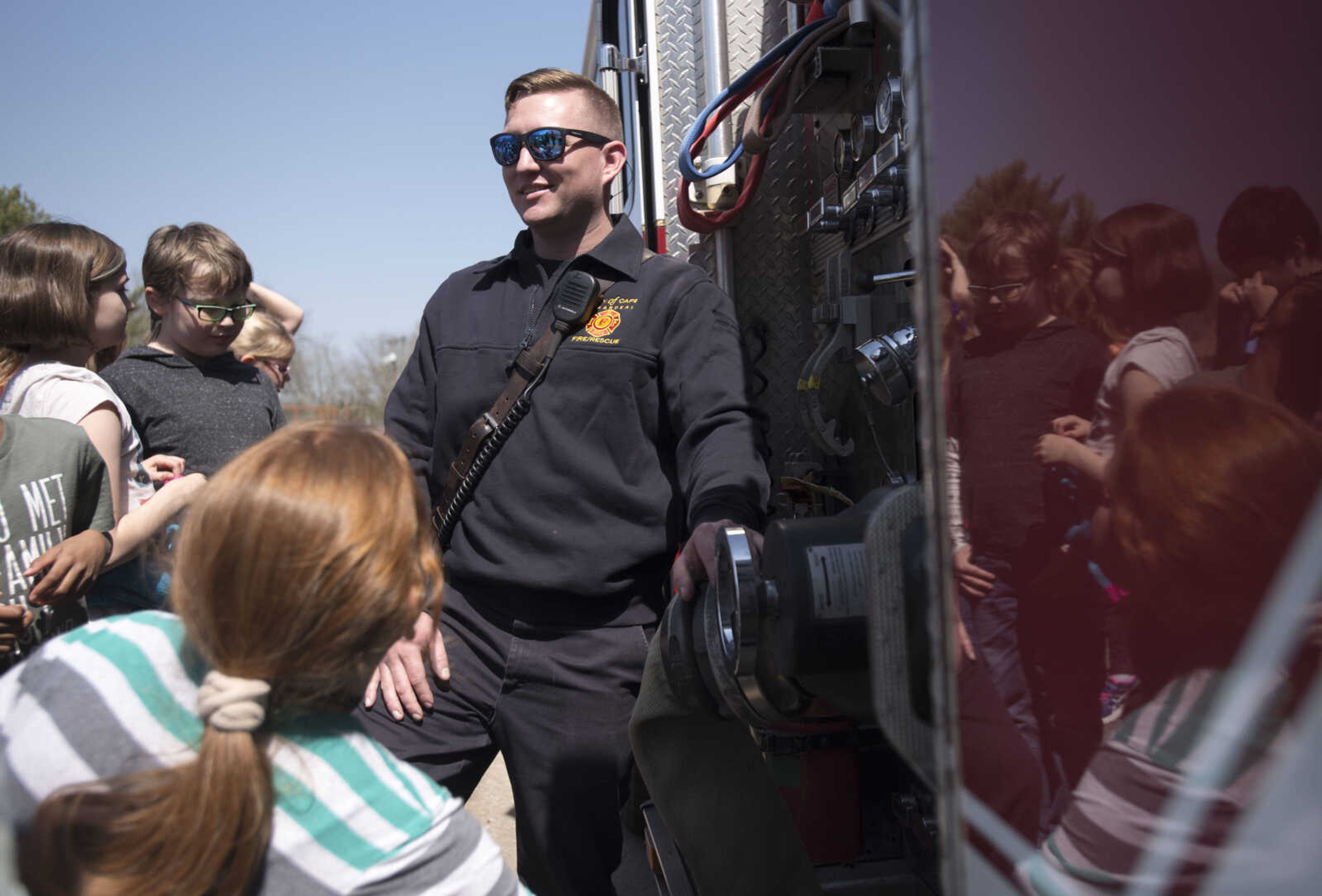 Second grade Alma Schrader Elementary students in the Project Charlie program surround Cape Girardeau firefighter David Uptmor while looking at a firetruck Tuesday, April 17, 2018, in Cape Girardeau.