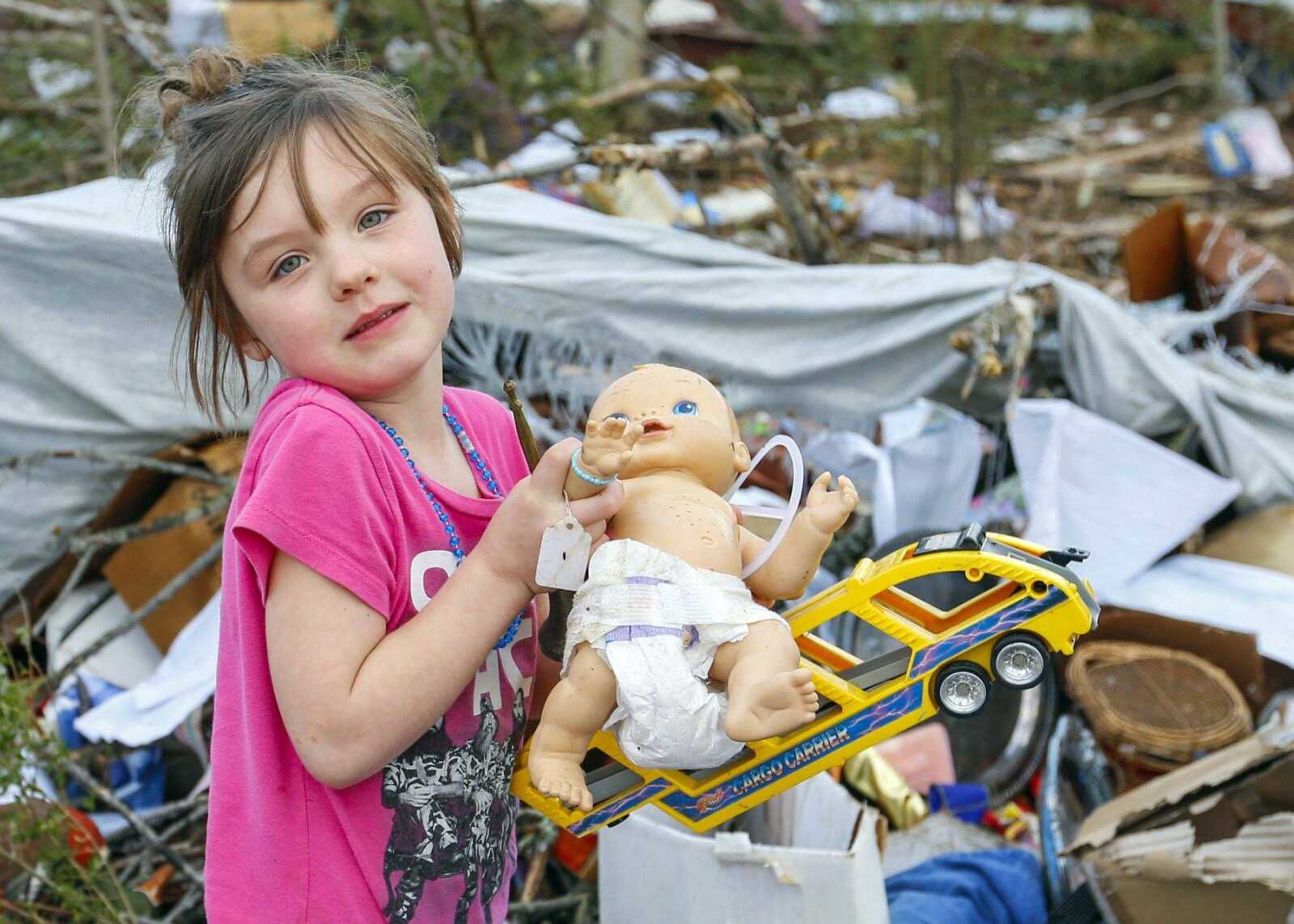 Serenity Brooks, 5, holds a baby doll as she digs for her belongings Wednesday after a suspected tornado ripped through the town of Rosalie, Alabama.