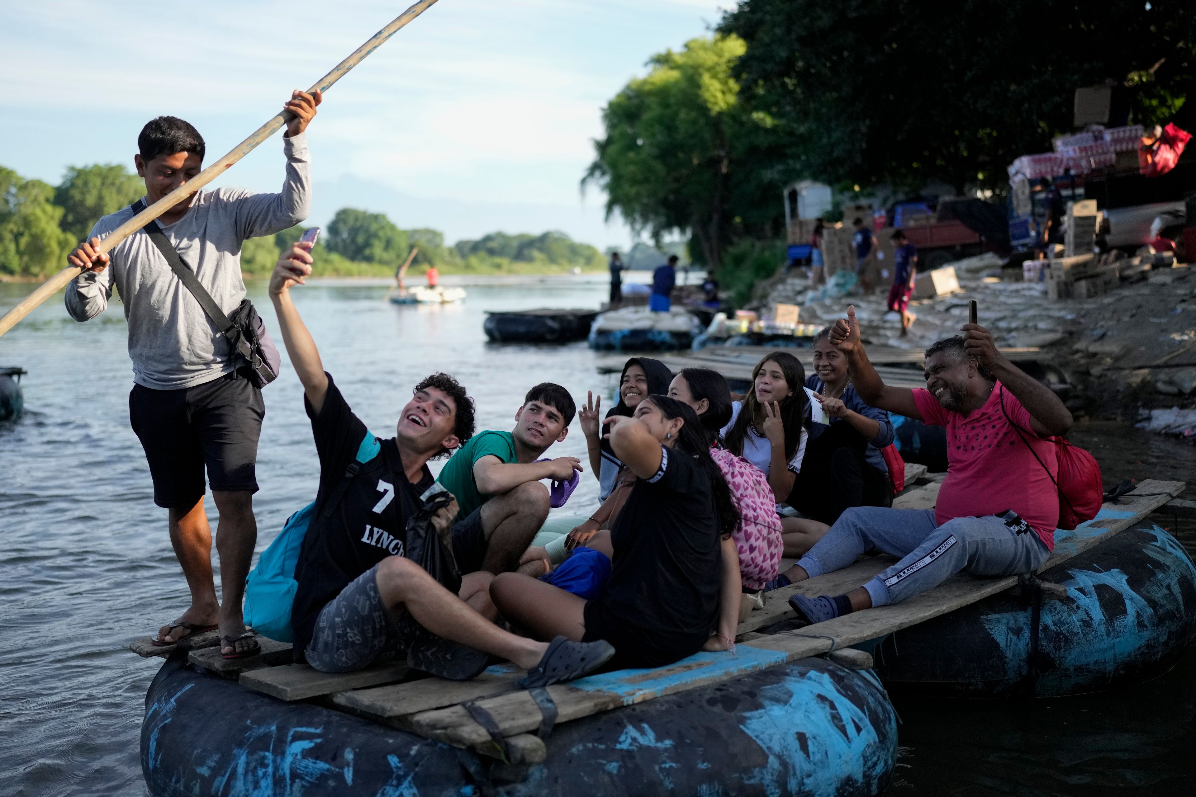 A Venezuelan migrant takes a selfie on a raft crossing the Suchiate River from Tecun Uman, Guatemala, to Mexico, Tuesday, Oct. 29, 2024. (AP Photo/Matias Delacroix)