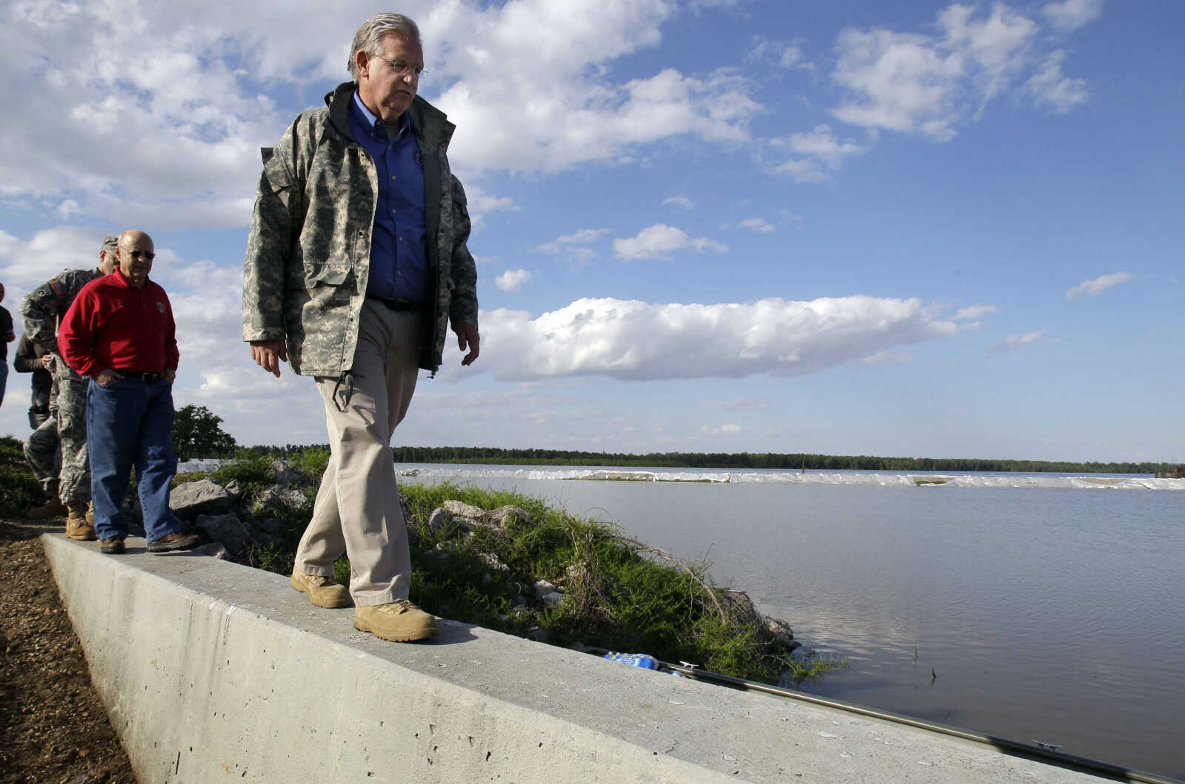 Missouri Gov. Jay Nixon walks atop a flood wall followed by Missouri state Rep. Terry Swinger, D-Caruthersville, left, as they tour flood preparations Tuesday, May 3, 2011, in Caruthersville, Mo. The town in southeast Missouri is bracing for a crest of 49.7 feet later this week. The flood wall protecting the town can hold back up to 50 feet, but a sustained crest will pressure the wall. Workers have been fortifying the concrete and earthen barrier with thousands of sand bags. (AP Photo/Jeff Roberson)