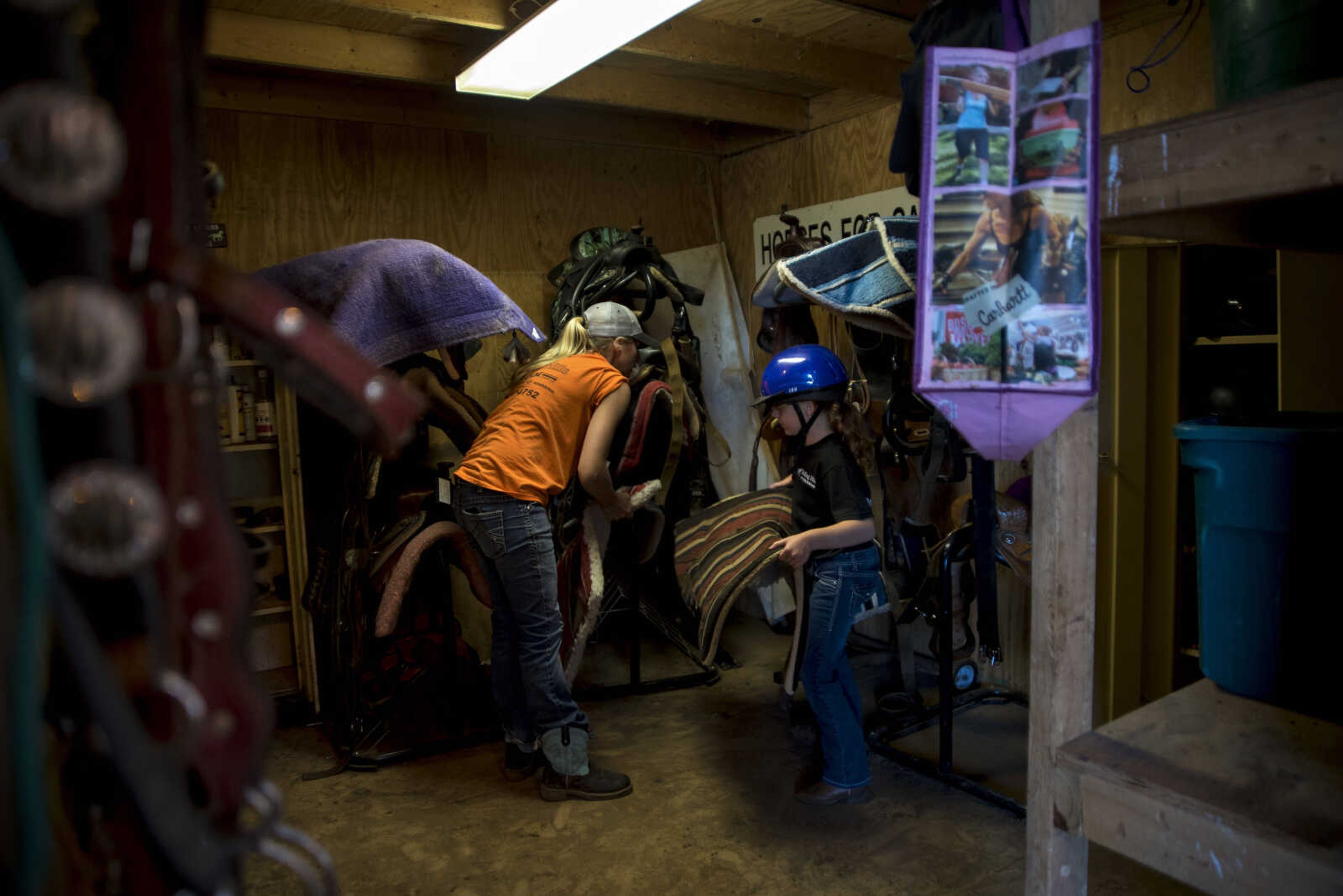 Kristin Carlton, left, and Payton Lynch, 6, get supplies for riding during the Rolling Hills Youth Day Camp Wednesday, June 7, 2017 in Cape Girardeau.