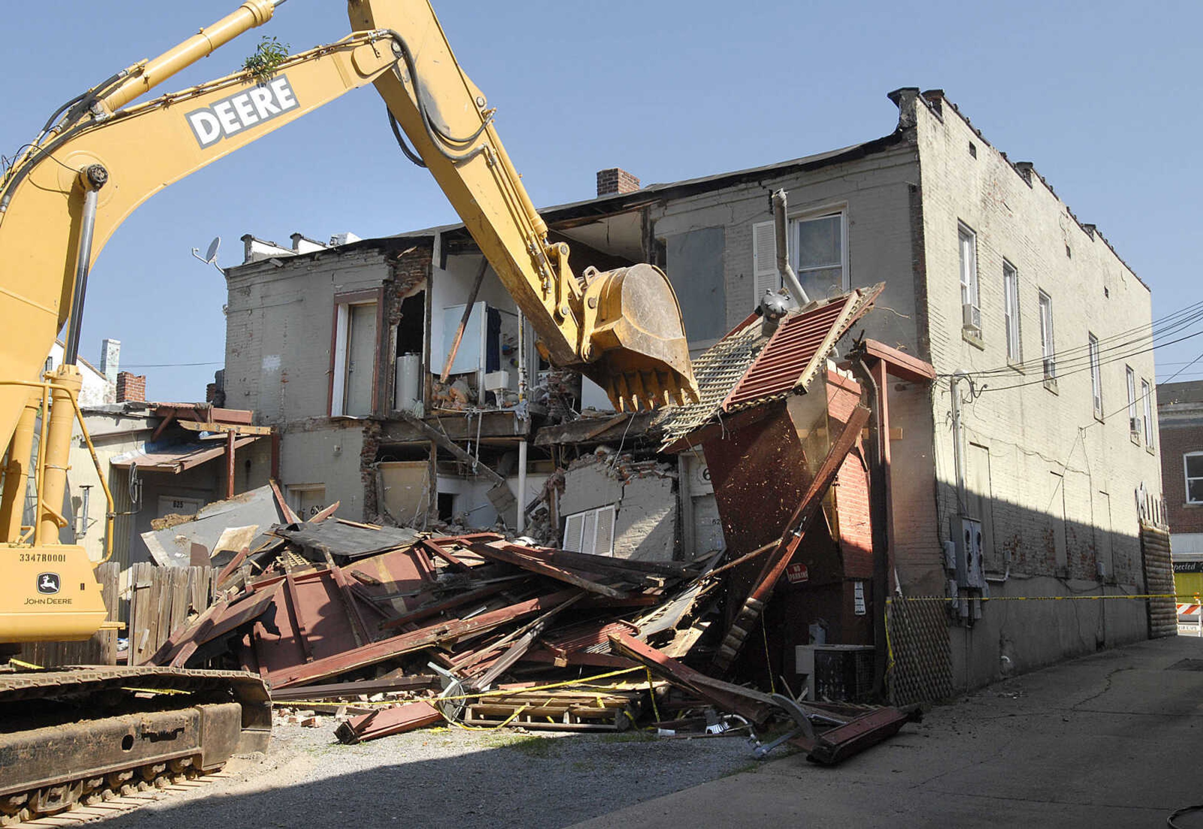 A demolition crew takes down the remainder of an outer wall in the rear of a building at 621-623 Broadway this morning. The wall collapsed Tuesday evening and parts of the wall have continued to fall since then. (Fred Lynch)