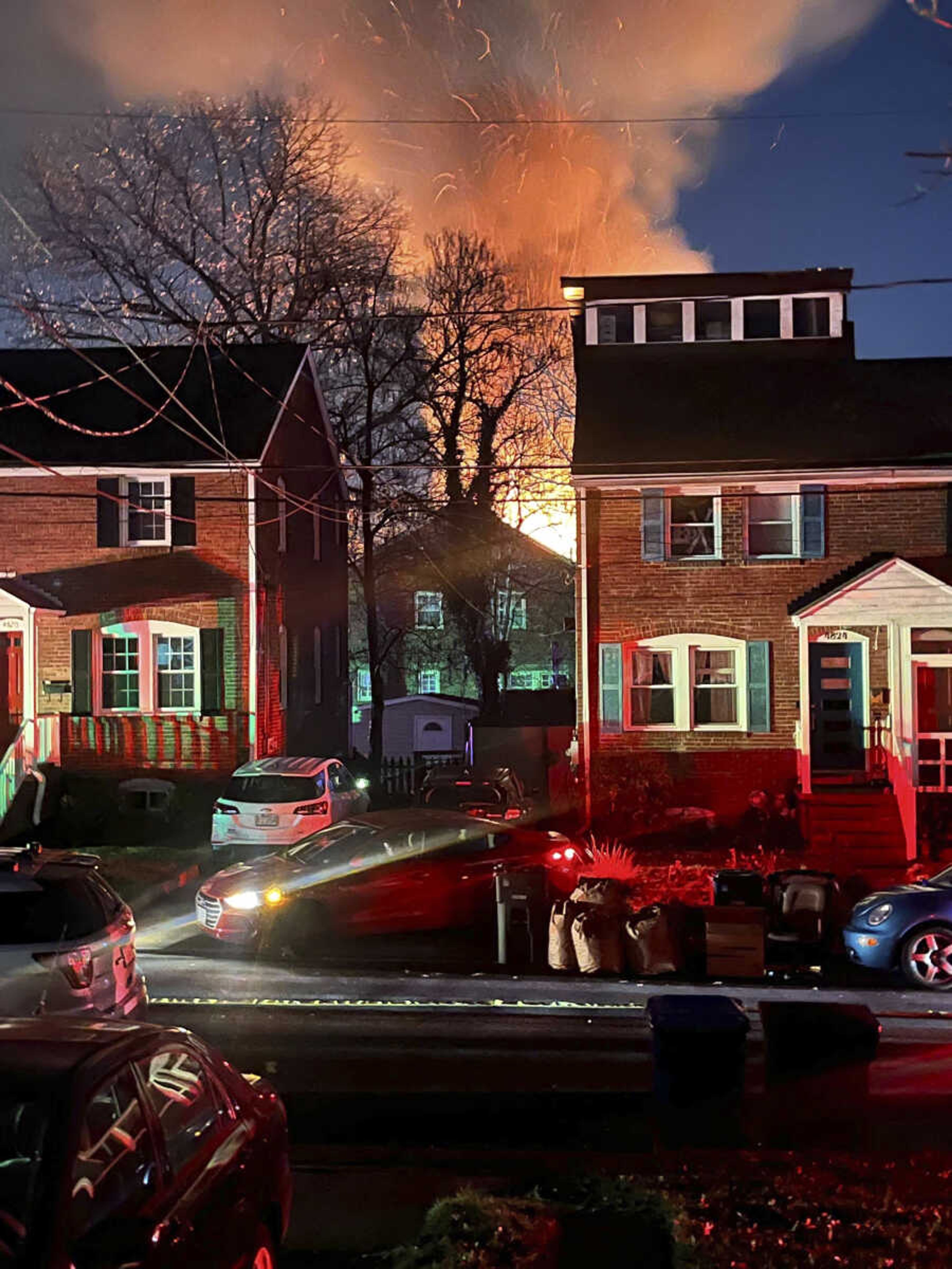 A home is seen exploding from a distance, Monday night in Arlington, Virginia.