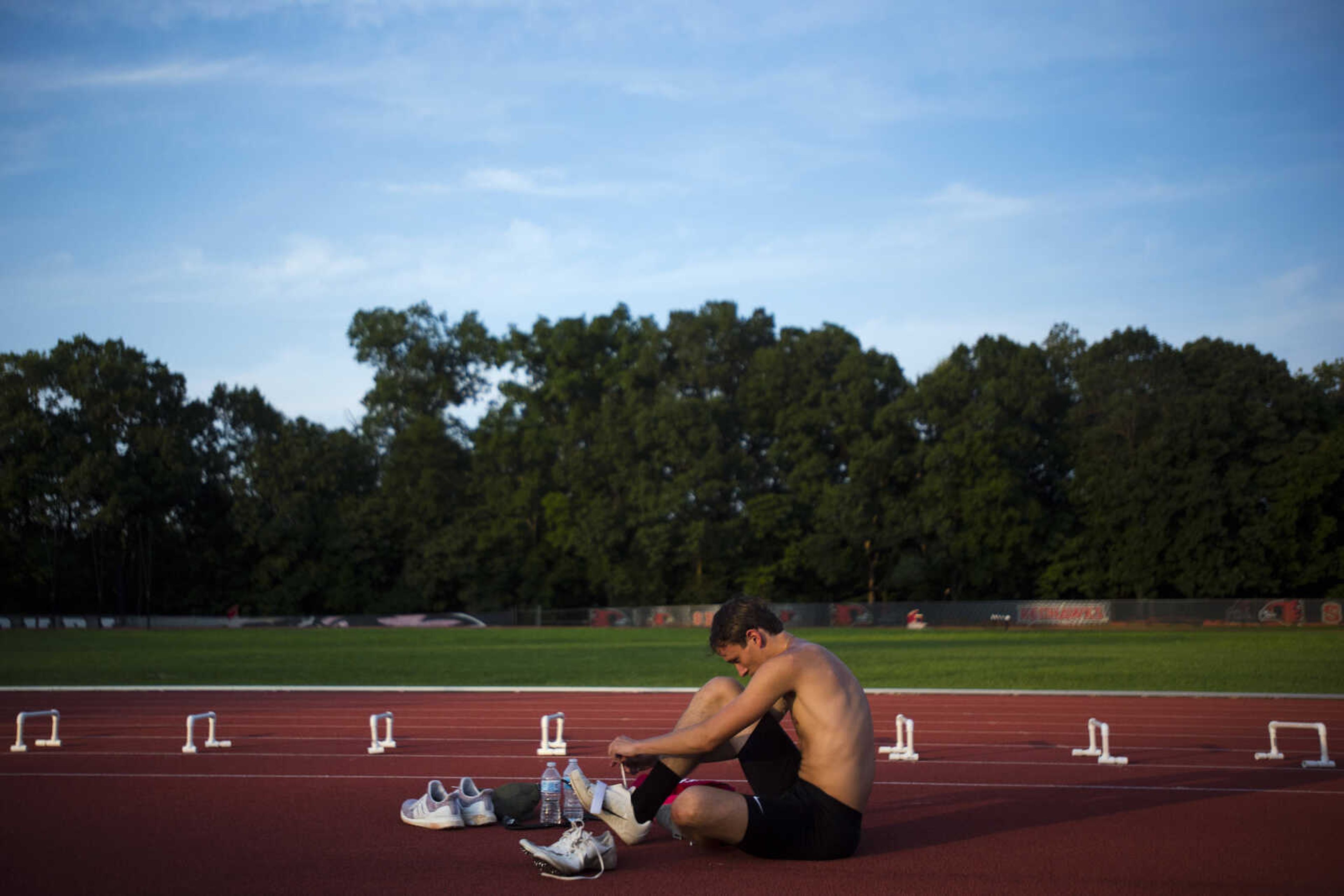 Cole Barker, of Dexter, changes out of his racing spikes before practicing long jump during a practice Thursday, July 25, 2019, at the Abe Stuber Track & Field Complex in Cape Girardeau.