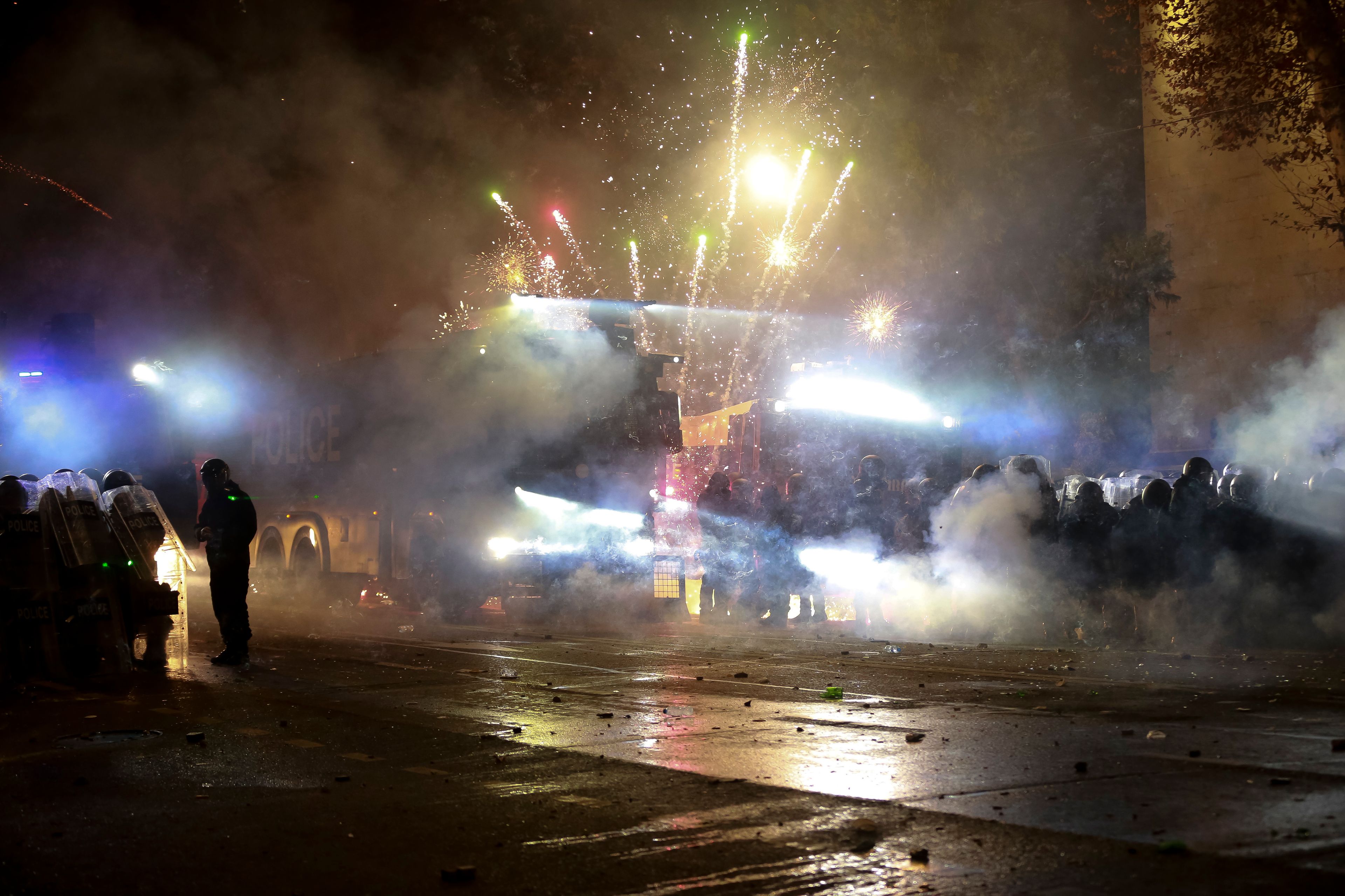 Demonstrators use firecrackers against police as police block a street to prevent protesters rallying against the government's decision to suspend negotiations on joining the European Union for four years, outside the parliament's building in Tbilisi, Georgia, early Saturday, Nov. 30, 2024. (AP Photo/Zurab Tsertsvadze)