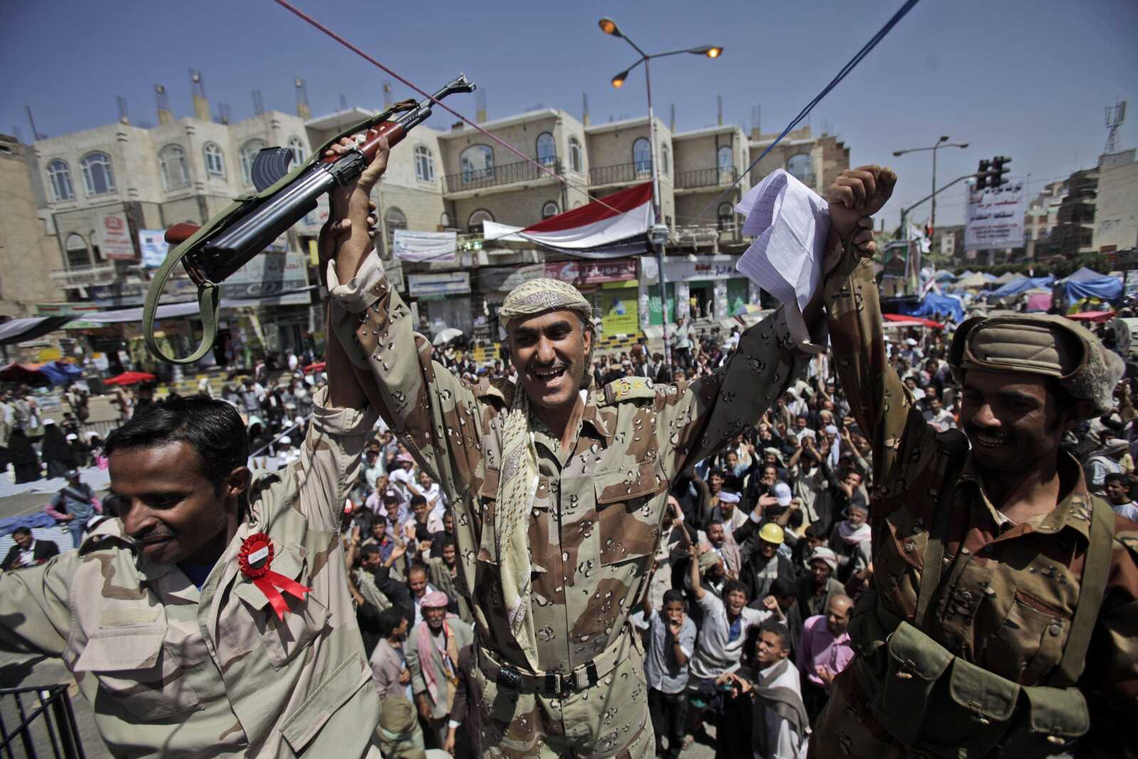 Yemeni army officers react as they join anti-government protestors demanding the resignation of Yemeni President Ali Abdullah Saleh, in Sanaa,Yemen, Monday, March 21, 2011. Three Yemeni army commanders, including a top general, defected Monday to the opposition calling for an end to President Ali Abdullah Saleh's rule, as army tanks and armored vehicles deployed in support of thousands protesting in the capital. With the defection, it appeared Saleh's support was eroding from every power base in the nation _ his own tribe called on him to step down, he fired his entire Cabinet ahead of what one government official said was a planned mass resignation, and his ambassador to the U.N. and human rights minister quit. (AP Photo/Muhammed Muheisen)