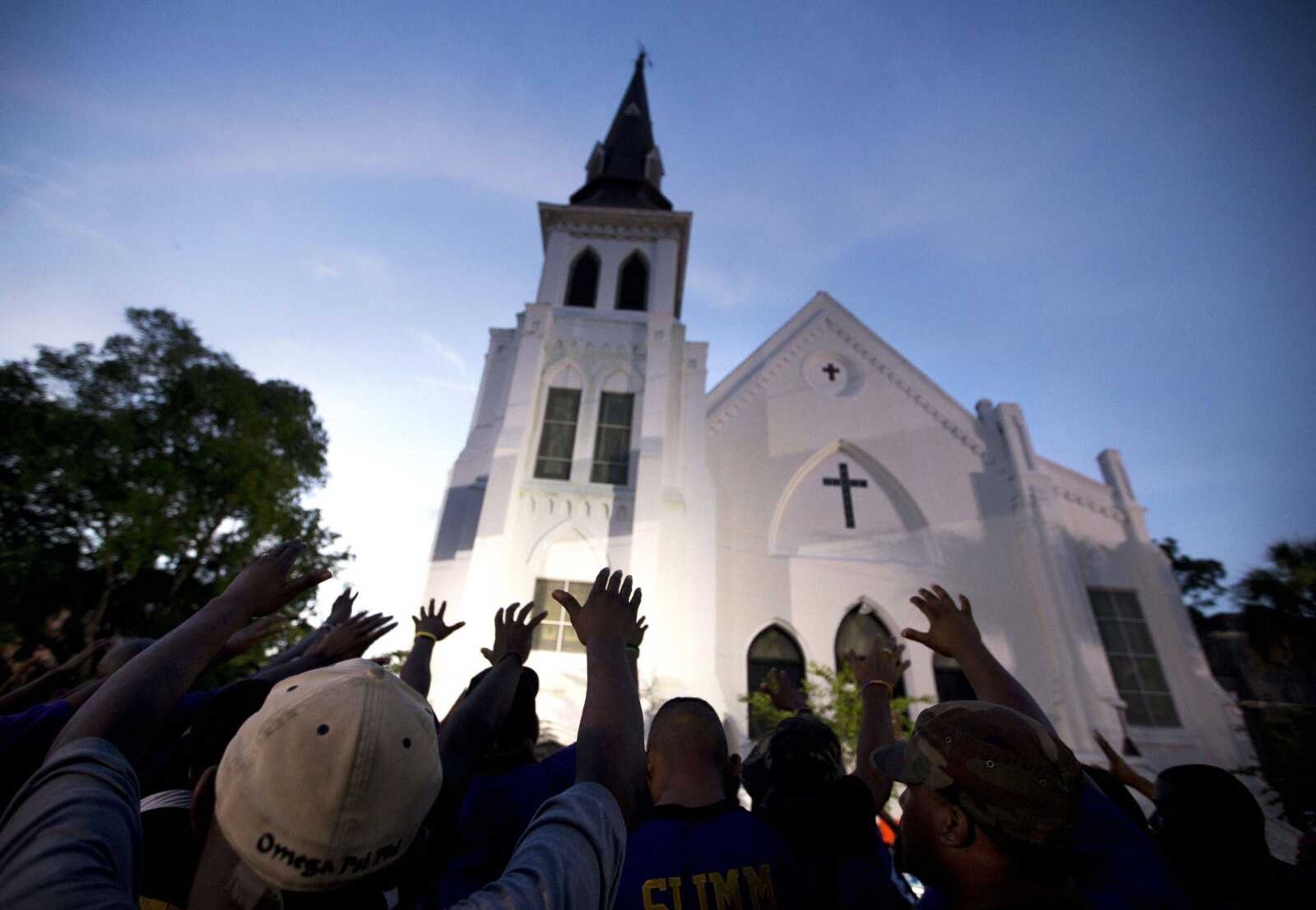 The men of Omega Psi Phi Fraternity Inc. lead a crowd of people in prayer June 19, 2015, outside the Emanuel AME Church after a memorial for the nine people killed by Dylann Roof in Charleston, South Carolina.