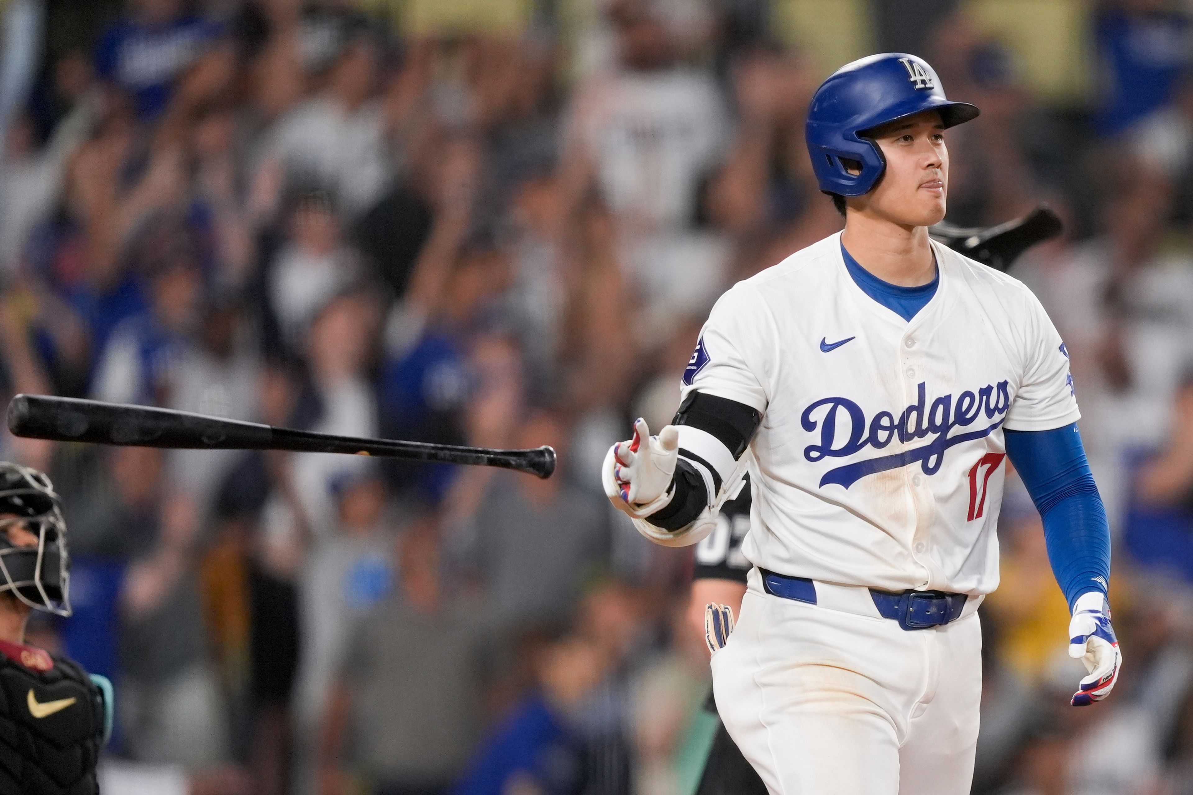 Los Angeles Dodgers designated hitter Shohei Ohtani tosses his bat after hitting a go-ahead two-run home run during the seventh inning of a baseball game against the Arizona Diamondbacks, Tuesday, July 2, 2024, in Los Angeles. (AP Photo/Ryan Sun)