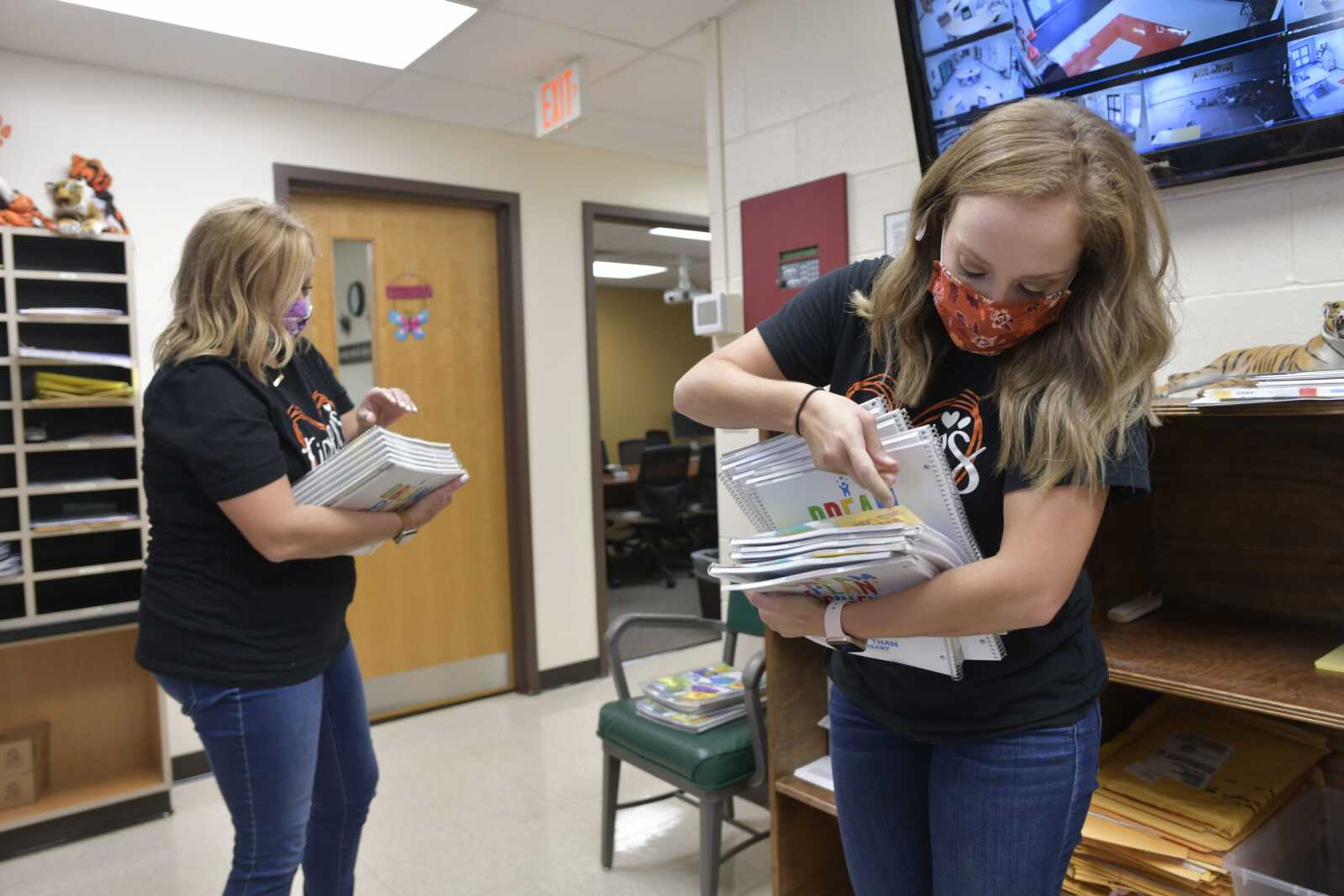 Fourth-grade teacher Allison Bradshaw, right, picks up a stack of planners for her students Tuesday, Aug. 18, 2020, at Clippard Elementary in Cape Girardeau.