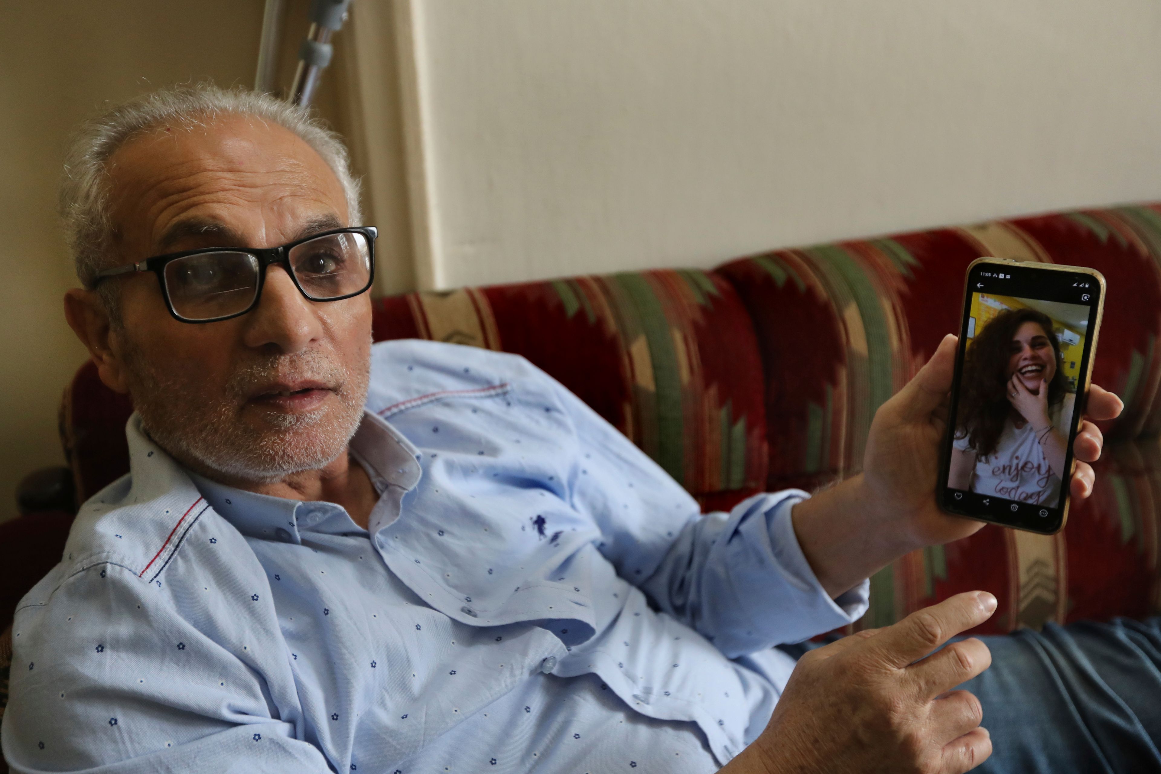 Abdul-Hamid Ramadan, shows a mobile picture of his daughter Julia who was one of more than 70 people killed on Sept. 29 when an Israeli airstrike struck a residential building the deadliest Israeli strike in the first week of escalation between Israel and Hezbollah, as he sits at his family house in the southern port city of Sidon, Lebanon, Thursday, Oct. 10, 2024. (AP Photo/Mohammed Zaatari)