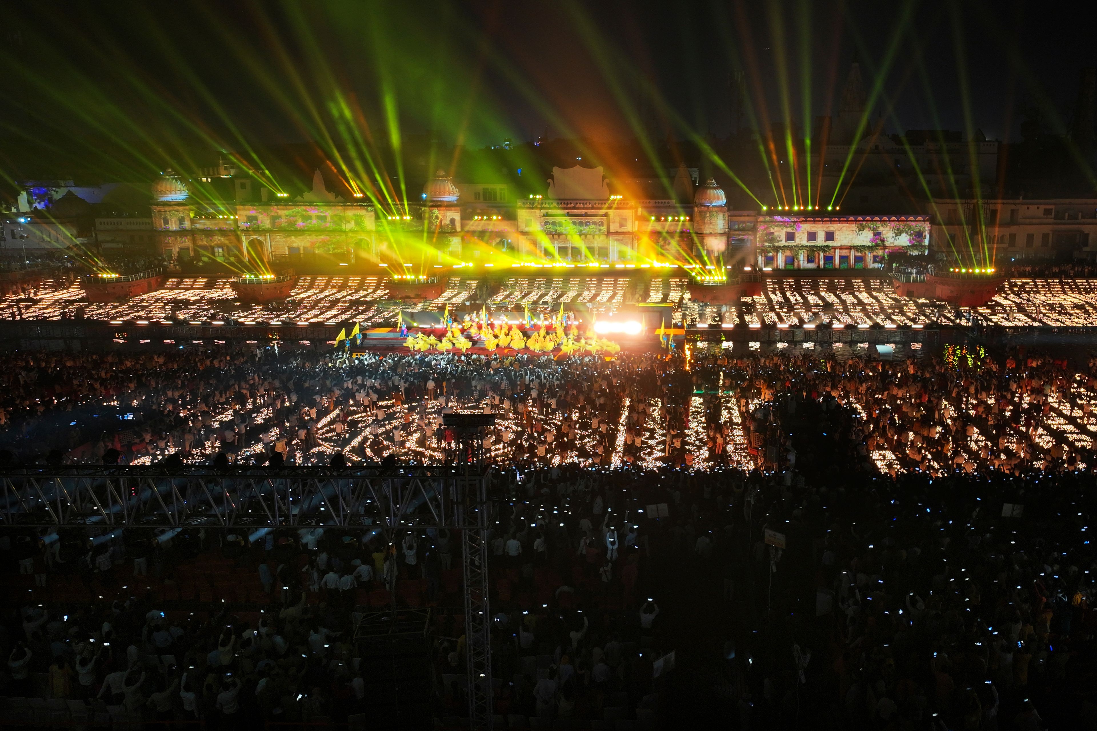 People watch a laser show after a record 2.51 million earthen oil lamps are lit along the Saryu river during Deepotsav celebrations, an event organized by the Uttar Pradesh state government on the eve of Diwali, in Ayodhya, India, Wednesday, Oct. 30, 2024. (AP Photo/Rajesh Kumar Singh)