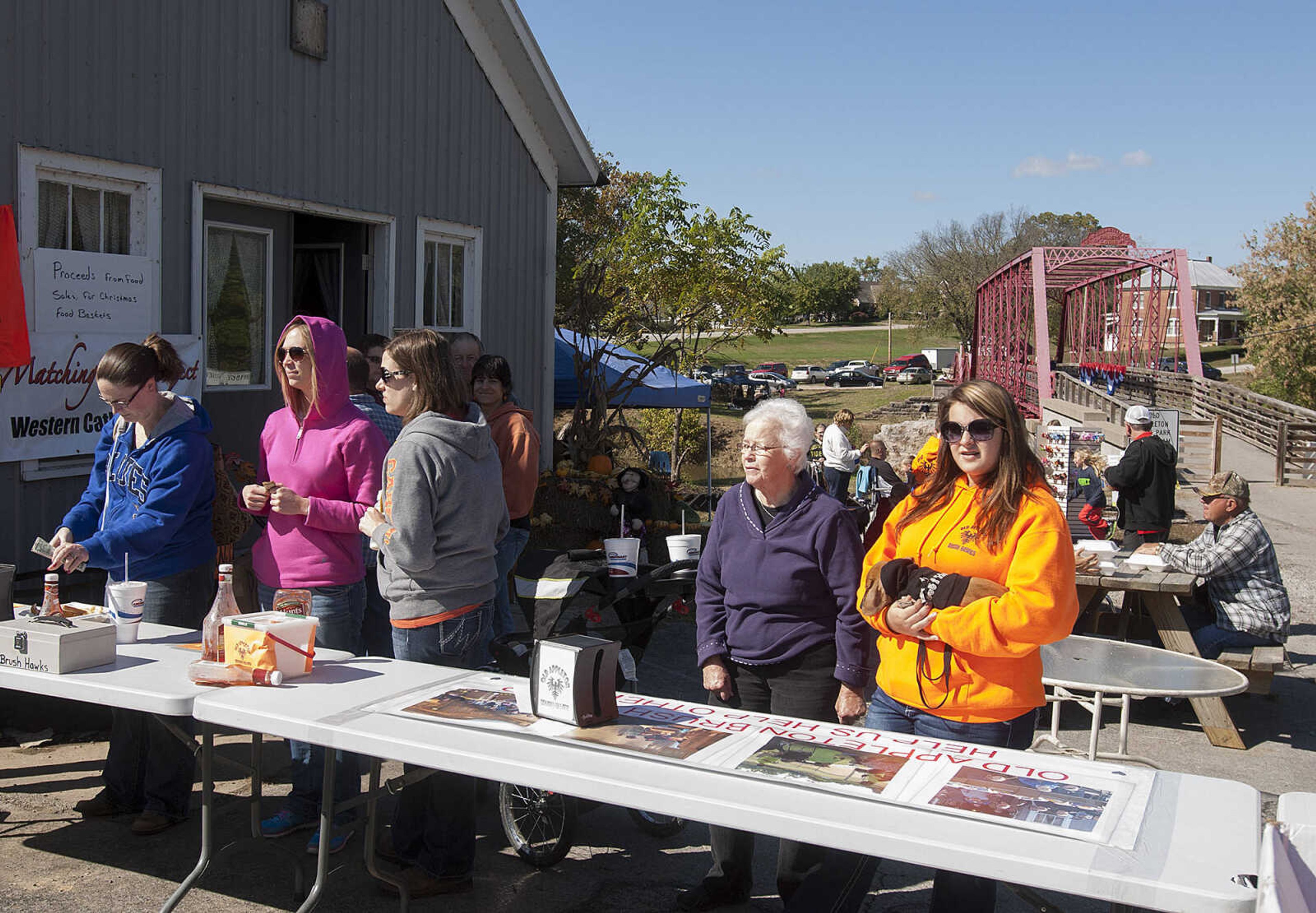 Customers wait in line to buy fried fish french fries and hot dogs from the Old Appleton Brush Hawks during the 2nd annual Old Appleton Fall Fest Saturday, Oct. 19, in Old Appleton, Mo. The money raised by selling food at the festival will be used to provide Christmas food baskets for the less fortunate.  The festival featured arts, crafts and food as well as free rides on the Bucky Express for children.