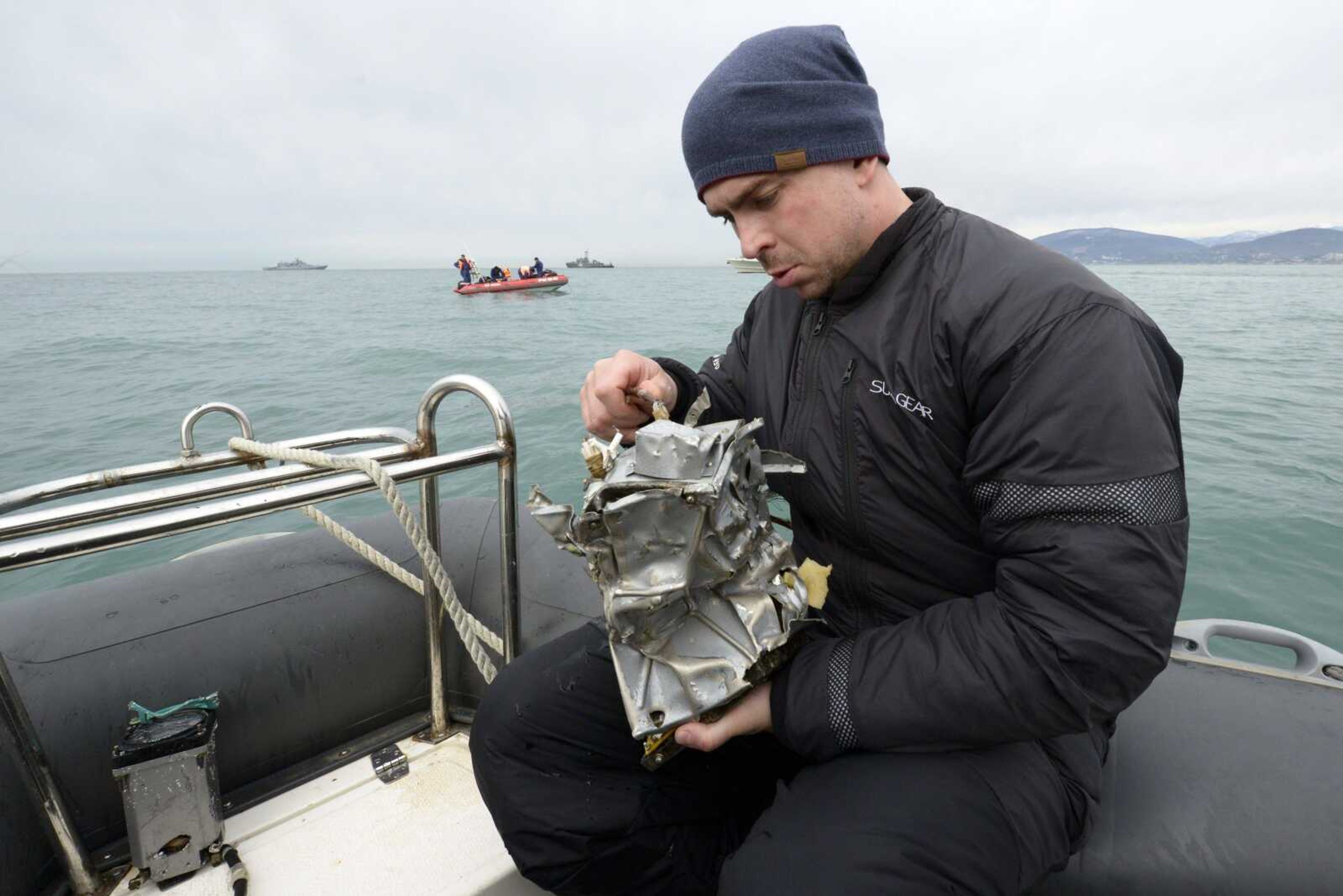 A Russian Emergency Ministry diver inspects a fragment of a plane Tuesday in the Black Sea outside Sochi, Russia. Investigators have recovered the flight-data recorder from a crashed Russian military plane.