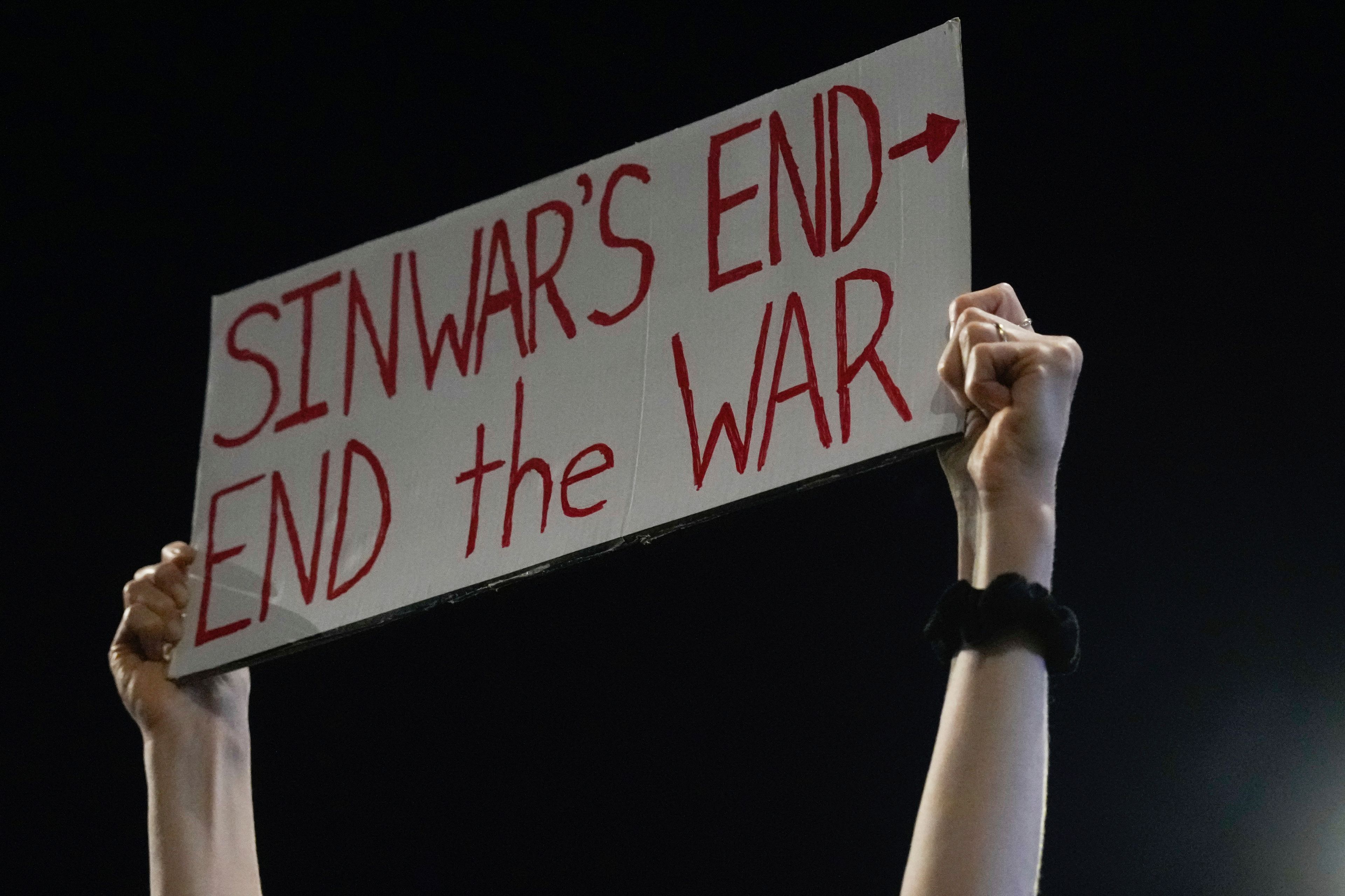 A demonstrator holds a sign about the killing of Hamas leader Yahya Sinwar during a protest calling for a cease-fire deal and the immediate release of hostages held by Hamas on Thursday, Oct. 17, 2024, in Tel Aviv, Israel. (AP Photo/Ariel Schalit)