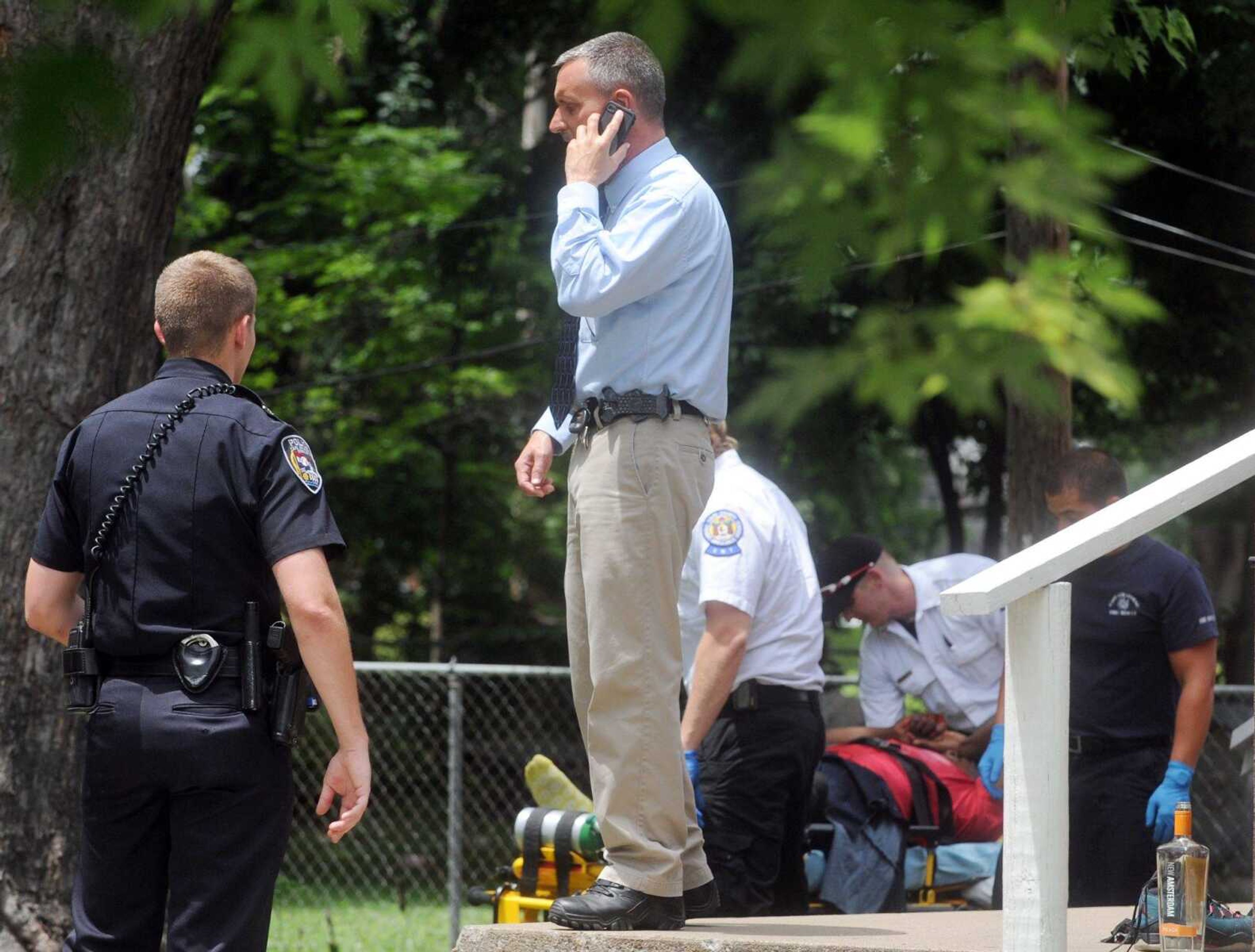 Paramedics from Cape County Private Ambulance wheel the victim of a shooting to the ambulance as members of the Cape Girardeau Police Department work the scene at 525 S. Sprigg St., Wednesday, June 17, 2015. The male victim was reported to be shot in the leg. (Laura Simon)