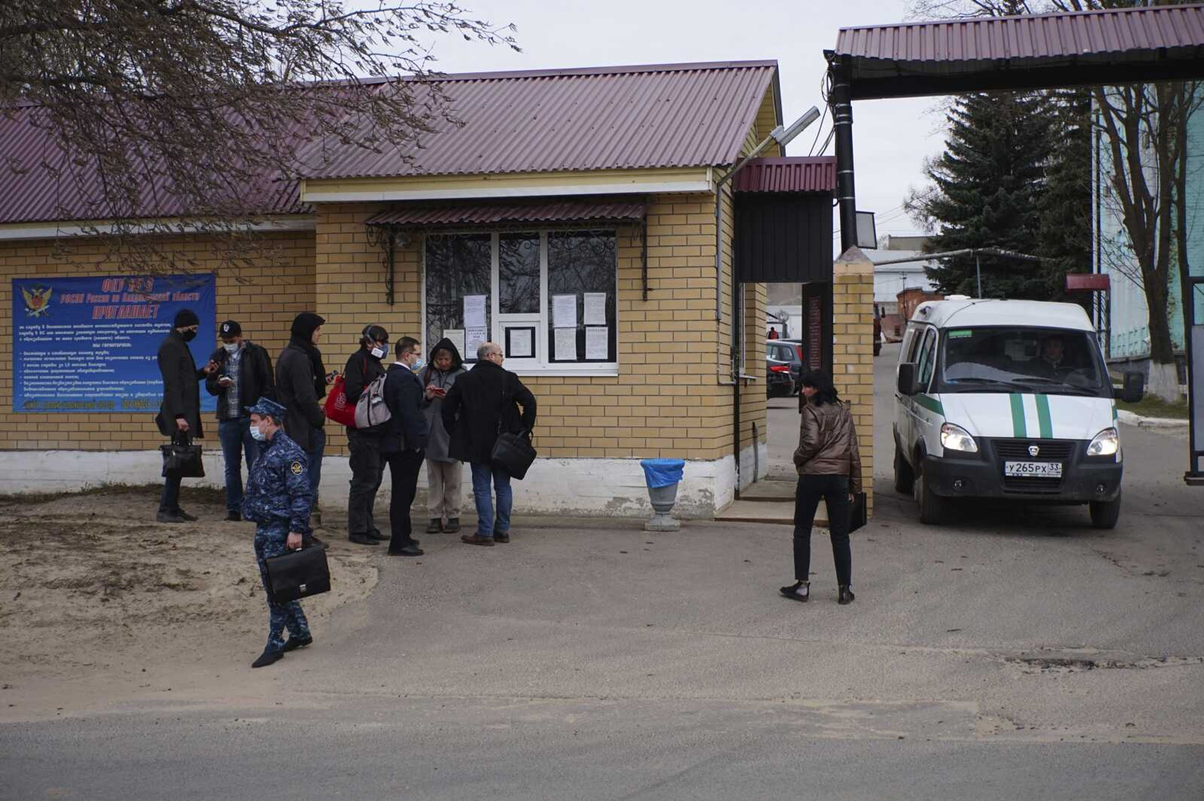 Journalists and Russian opposition leader Alexei Navalny's doctors who were prevented from seeing him at a prison clinic gather Tuesday in front of the penal colony where a hospital for convicts is located in Vladimir, Russia.