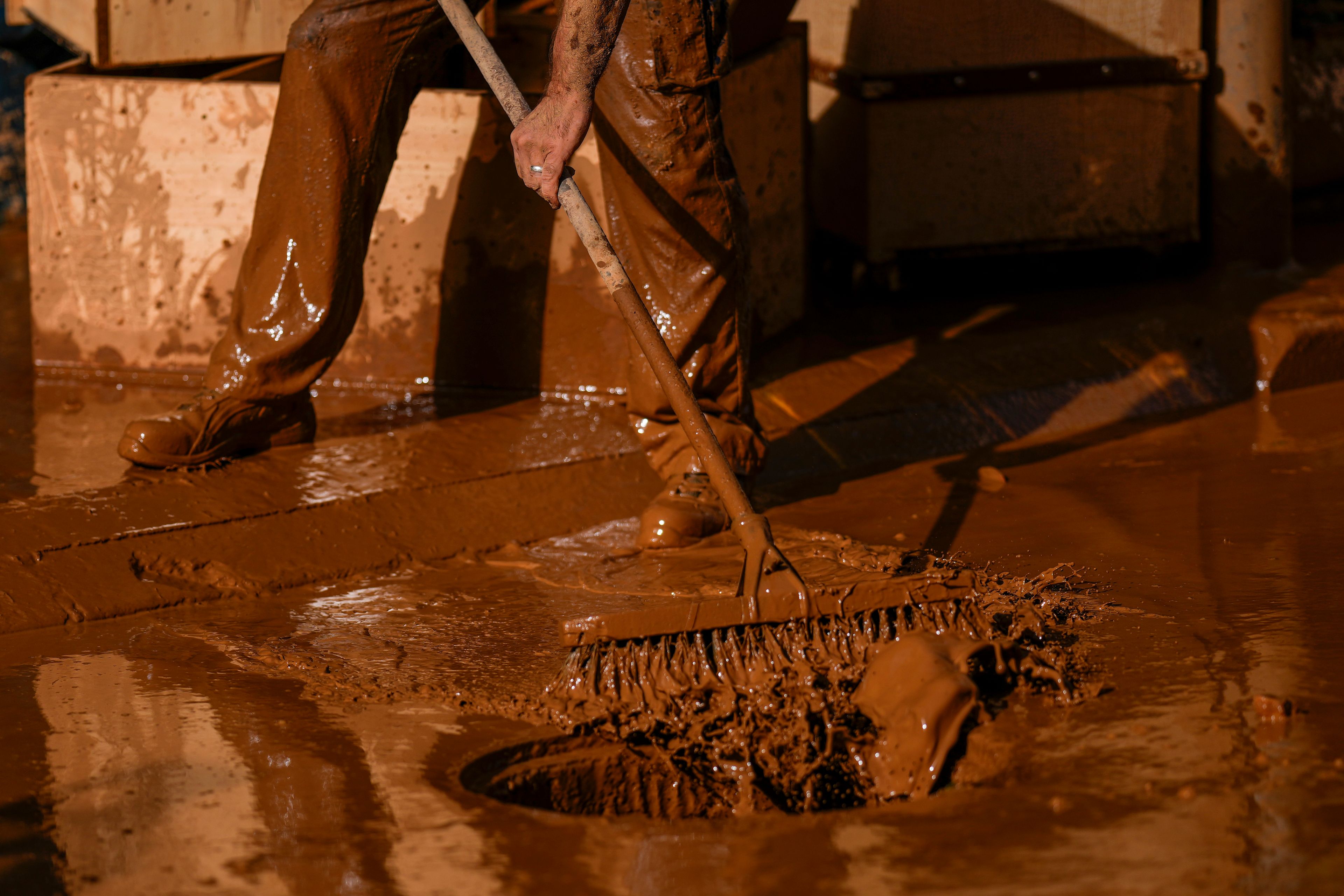 A person removes mud after the floods in Utiel, Spain, Wednesday, Oct. 30, 2024. (AP Photo/Manu Fernandez)