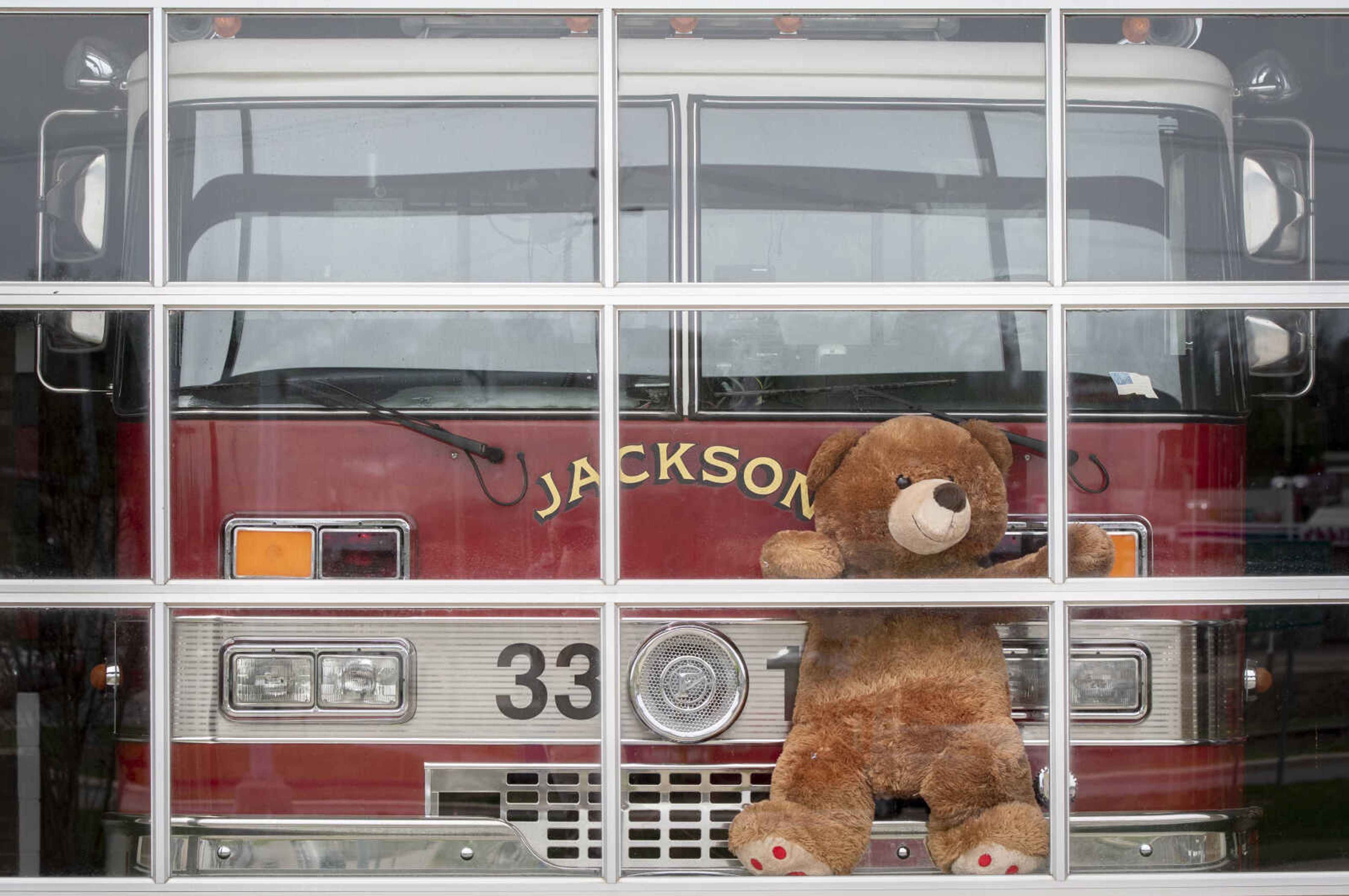 A stuffed-animal bear sits with a fire vehicle Monday, March 30, 2020, at Jackson Fire Rescue's Station 1 in Jackson. "We are ready for all the bear hunters in Cape County. As [you] drive by our Station 1 in Jackson make sure to be on the lookout but don't be alarmed, our bear is pretty friendly," Jackson Fire Rescue posted on its Facebook page. Stuffed animals are showing up in windows around the globe giving kids a "social-distancing-safe scavenger hunt activity during coronavirus lockdowns," according to a Monday USA Today article.