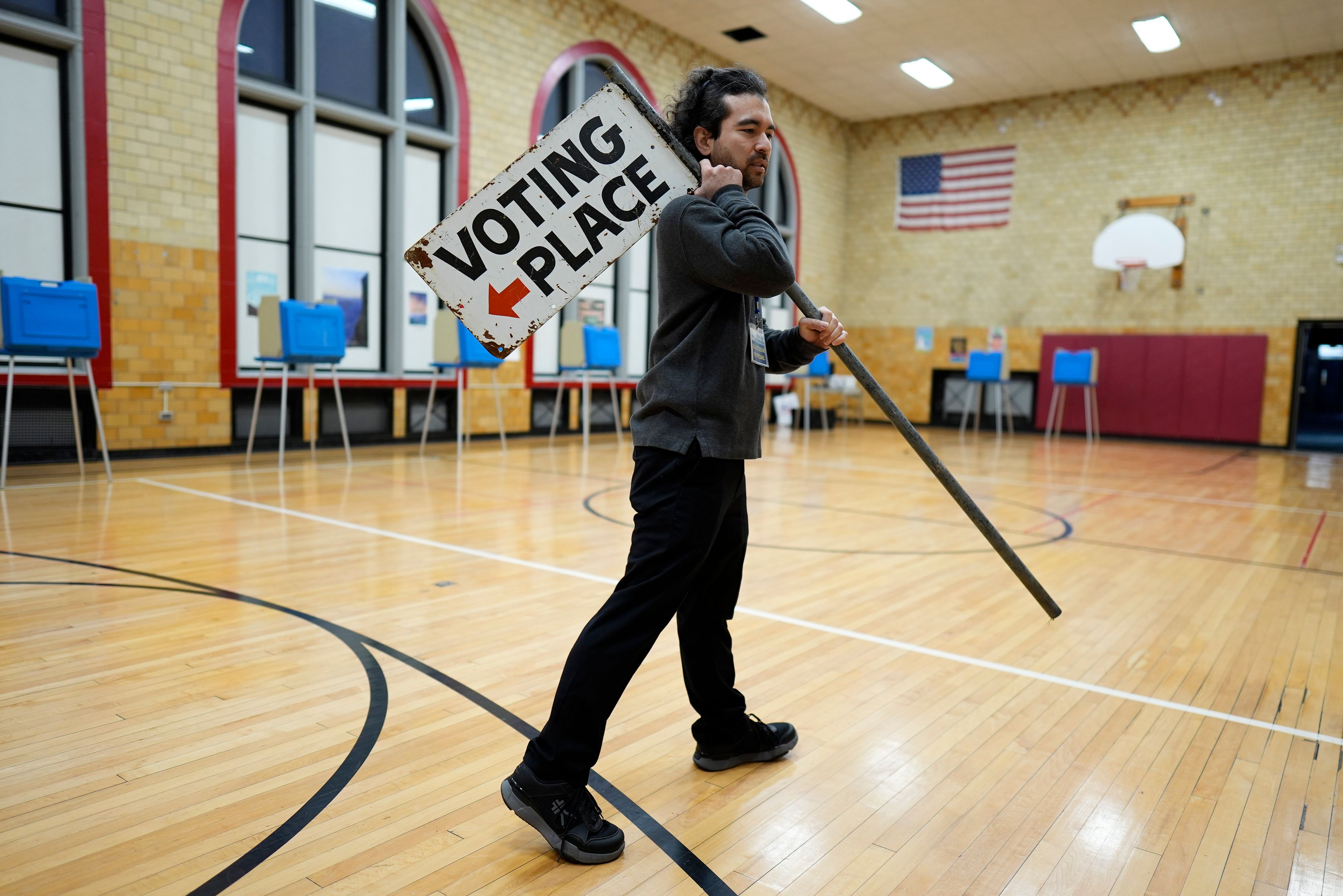 Election day worker Sean Vander Waal prepares to open a polling place,Tuesday, Nov. 5, 2024, in Dearborn, Mich. (AP Photo/Charlie Neibergall)