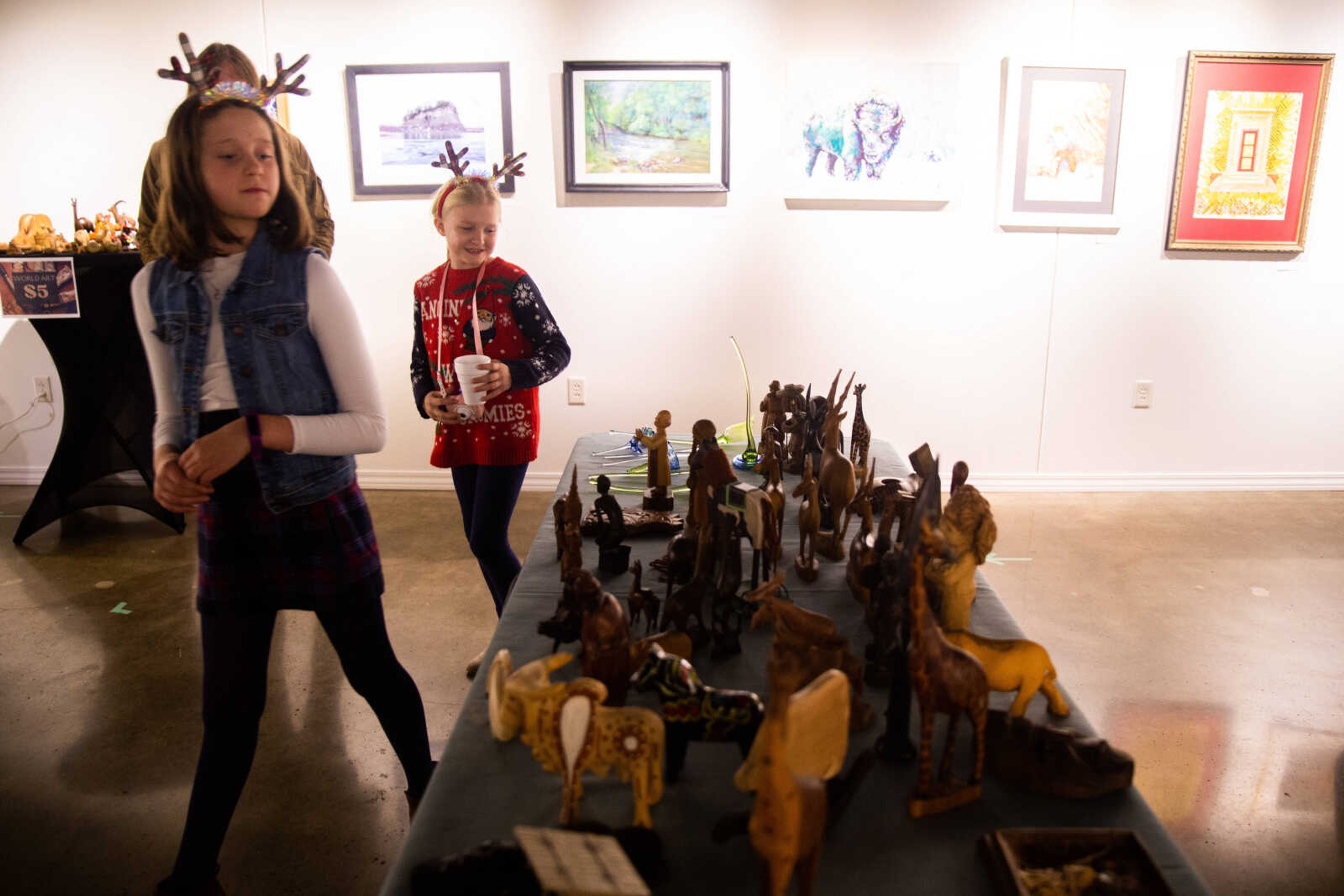 Lillian Gaither, 8, and Elliana Swoboda, 9, admire artworks at the Southeast Art Council's world art exhibit&nbsp;on Friday, Dec. 2 in Cape Girardeau.